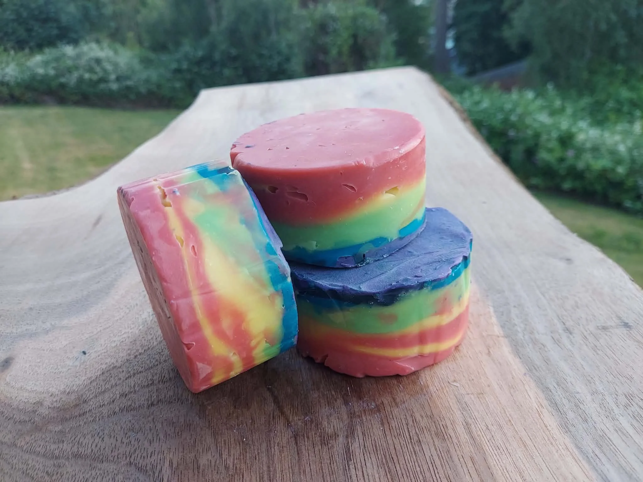 Round bar of soap colored in rainbow layers.
