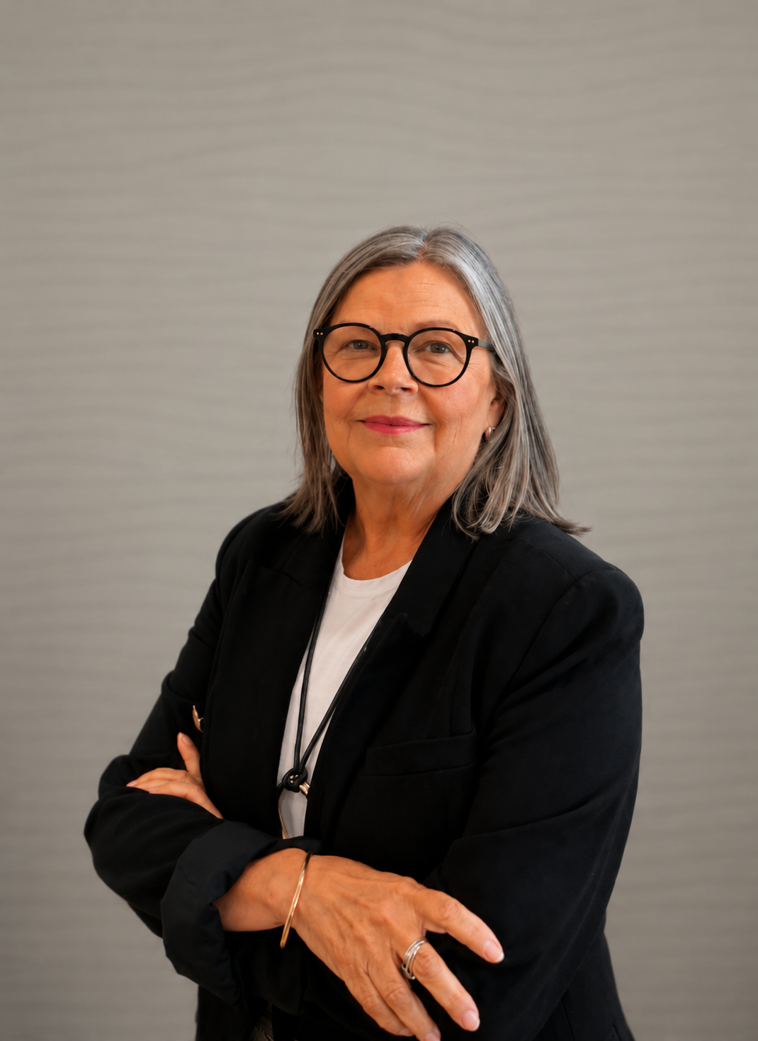 Celia is facing the camera, smiling with her arms crossed.