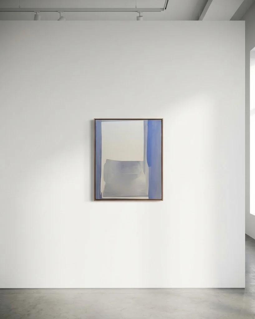 Minimalist art gallery with a framed abstract painting on a white wall, featuring shades of blue, gray, and white.