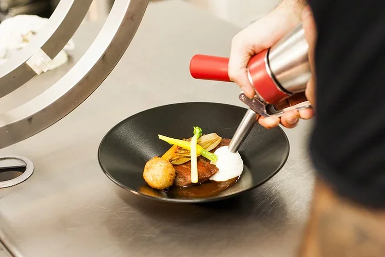 Verfijnd gerecht tijdens een private dining ervaring, afgewerkt met precisie door Ann Steyaert Atelier.