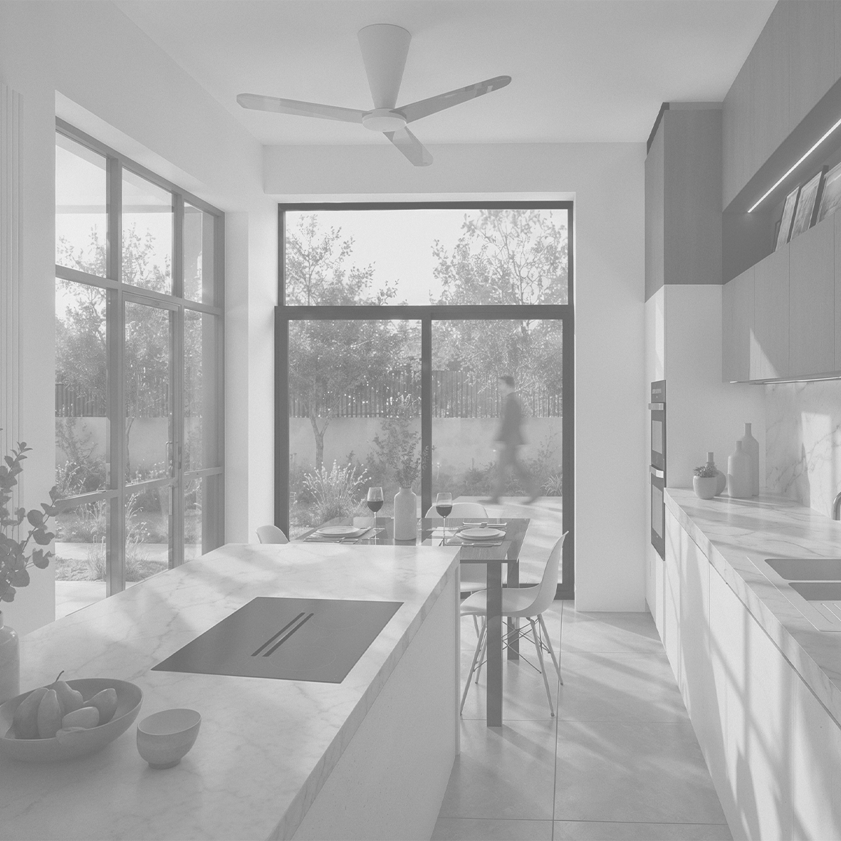 Cuisine moderne avec îlot en marbre, table à manger en bois avec quatre chaises, grande baie vitrée, porte-fenêtre, plafond avec ventilateur, décoration minimaliste, vue sur un jardin avec arbres et haies.