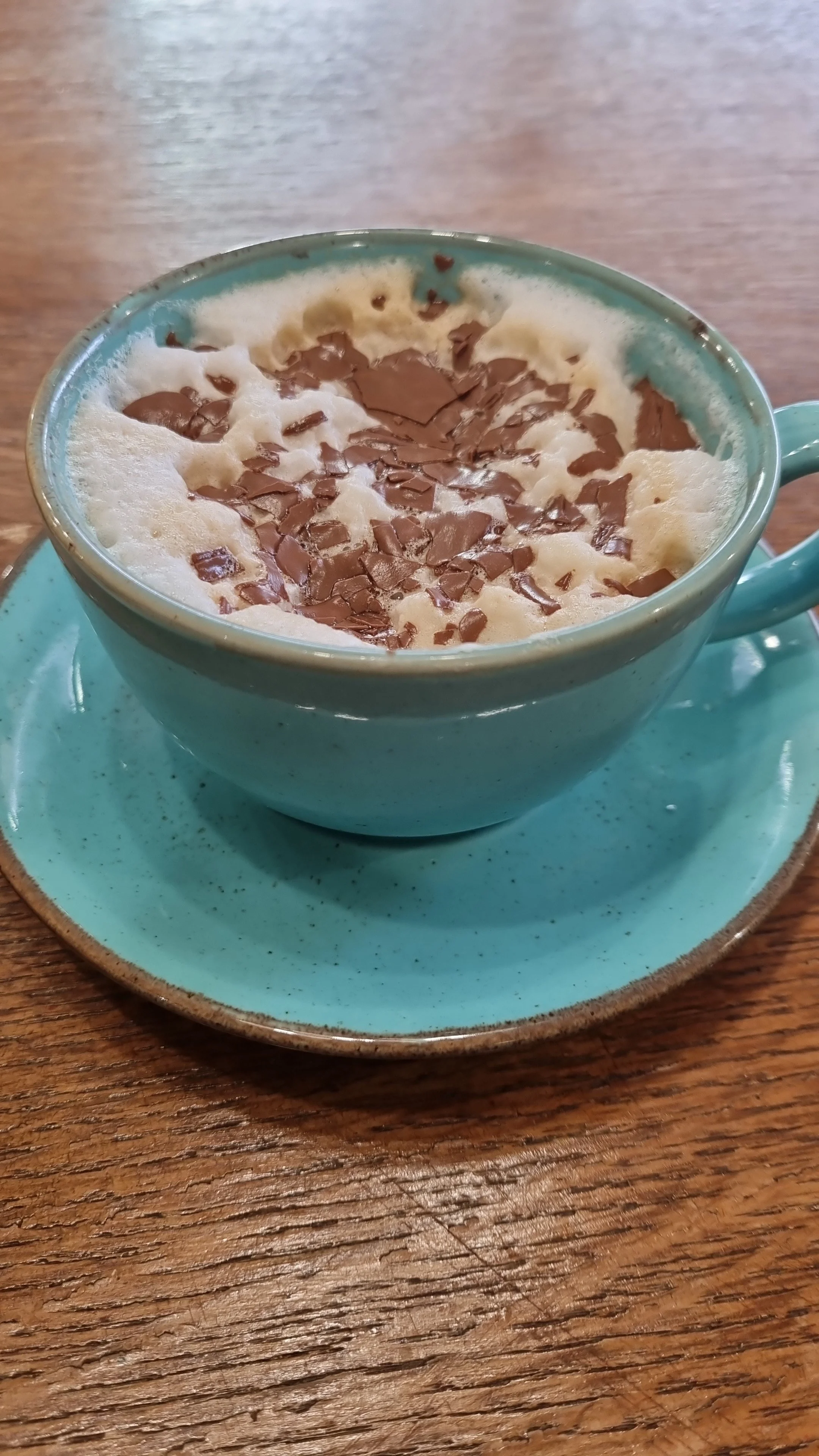a cappucino in a blue cup with chocolate sprinkles