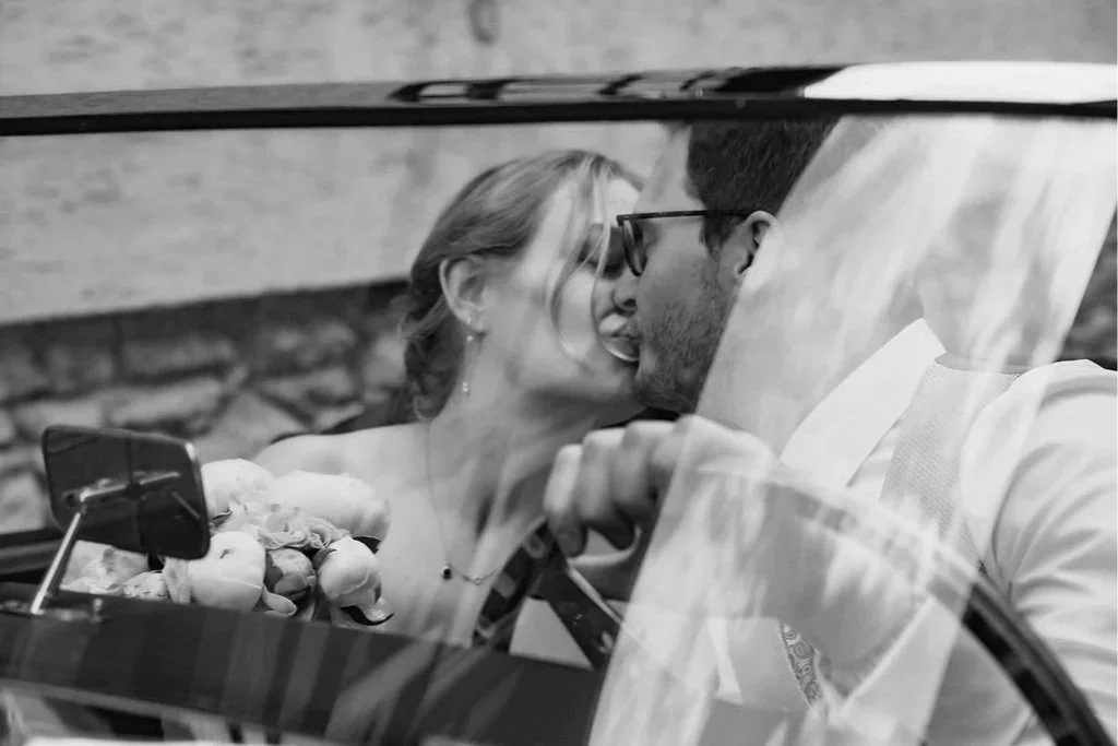 Groom and bride kissing in a classic car captured by cinematic wedding photographer Jessica Di Salvo.