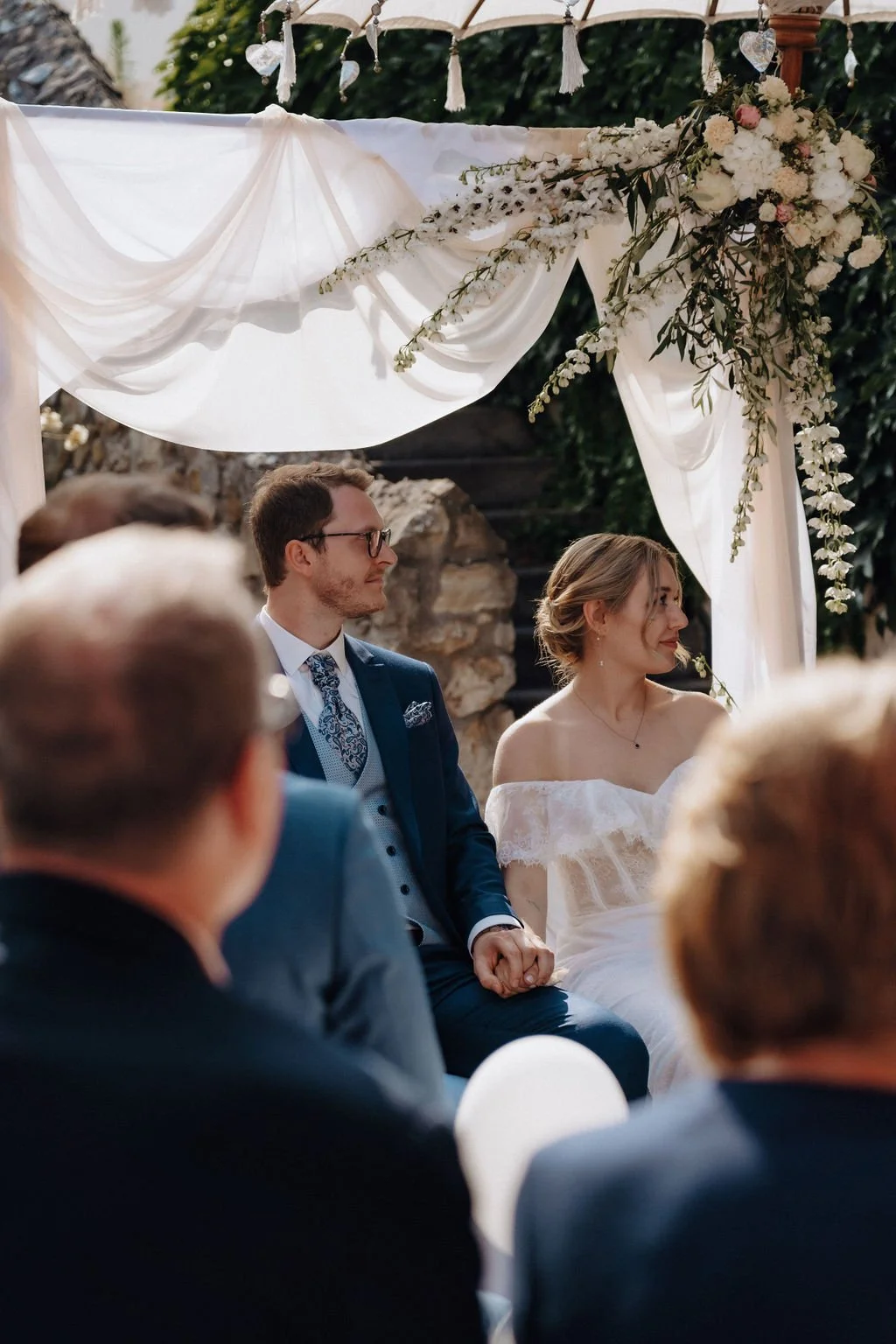 Couple captured through the silhouettes of guests during ceremony, photographed by wedding photographer Jessica Di Salvo Hochheim, Germany.