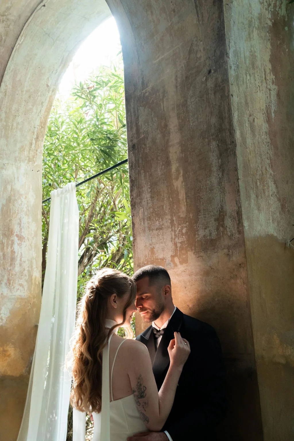 Intimate moment of couple with old wall behind them by cinematic photographer Di Salvo, Lake Como, Italy.