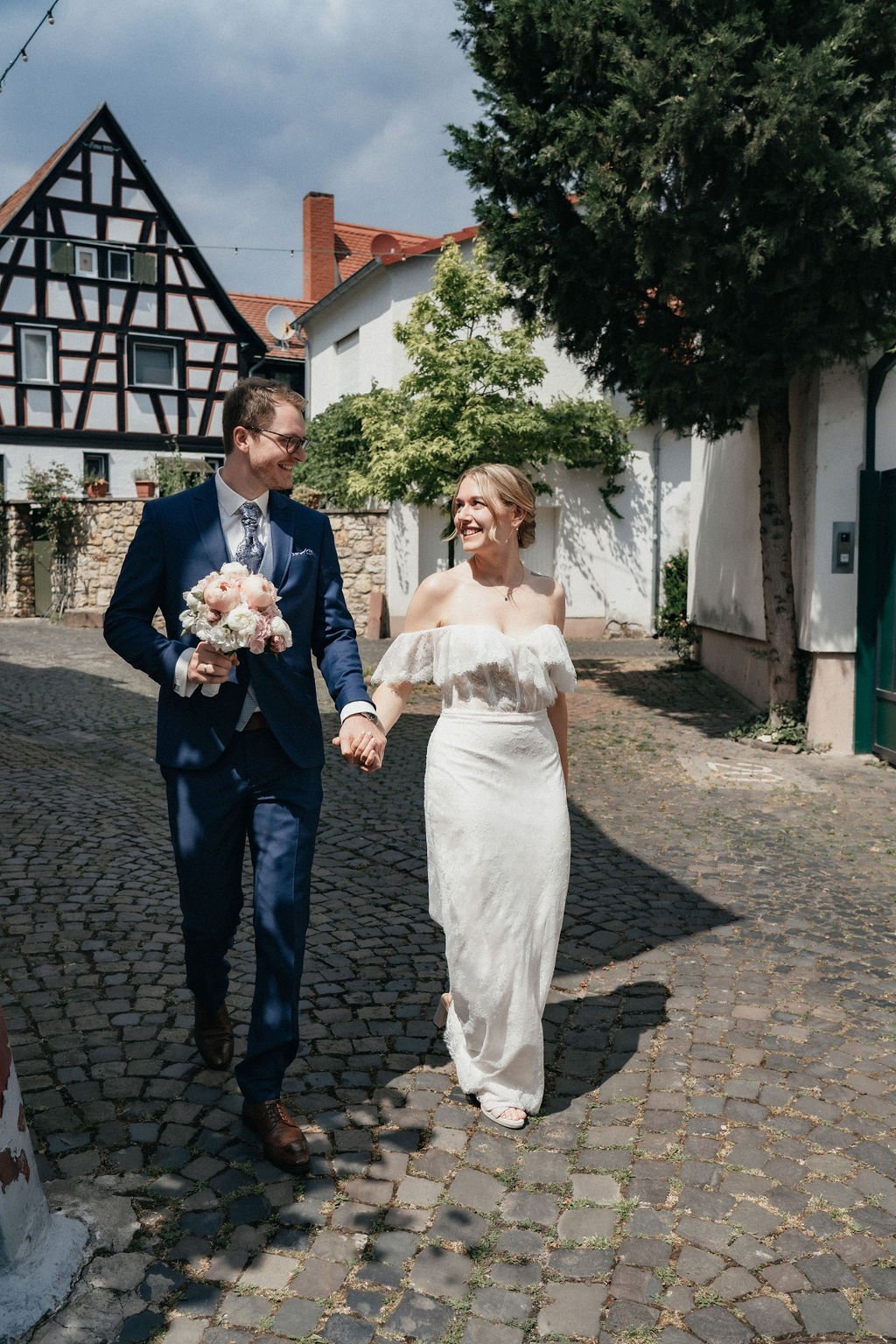 Bride and groom smiling at each other as they walking side by side by wedding photographer Jessica Di Salvo.