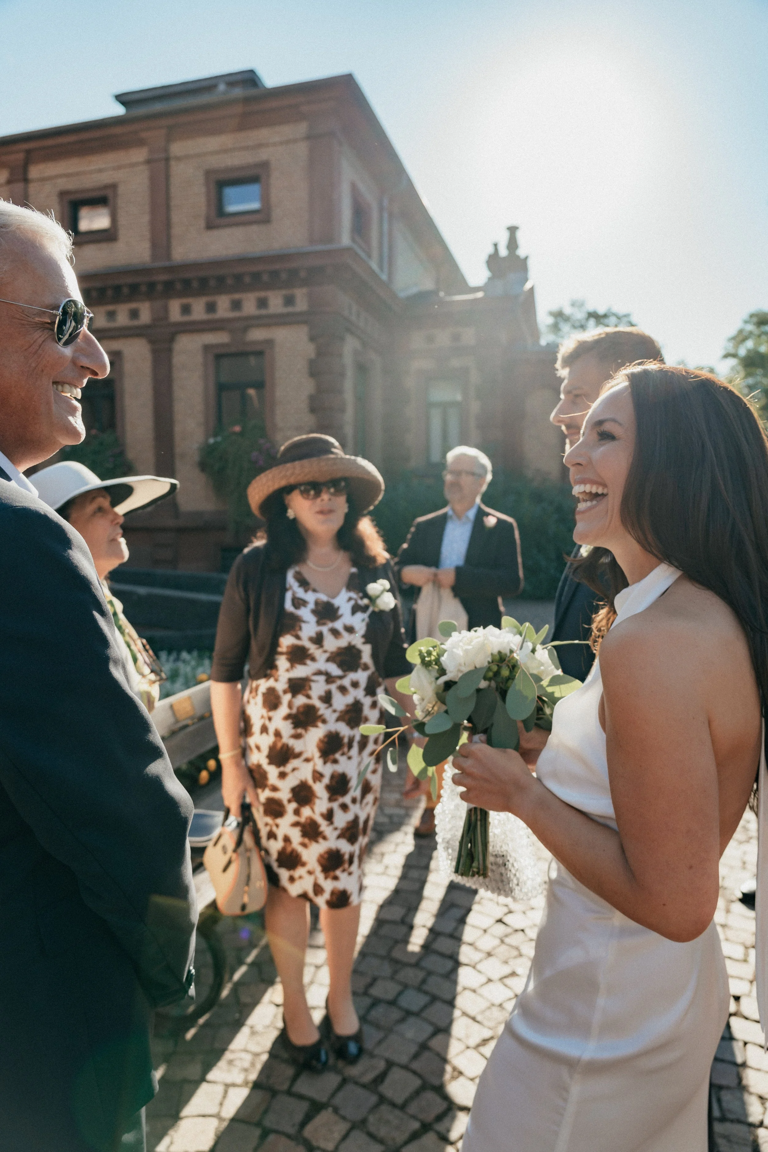 Bride and Groom laughing and talking with family and friends picture by wedding photographer Jessica Di Salvo.
