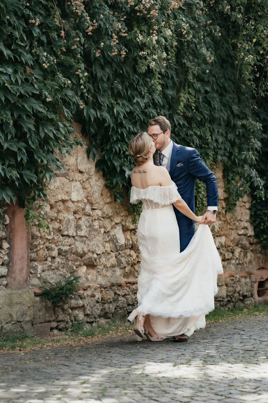 The Kiss of a married couple in front of an old stone wall photographed by wedding photographer Di Salvo.