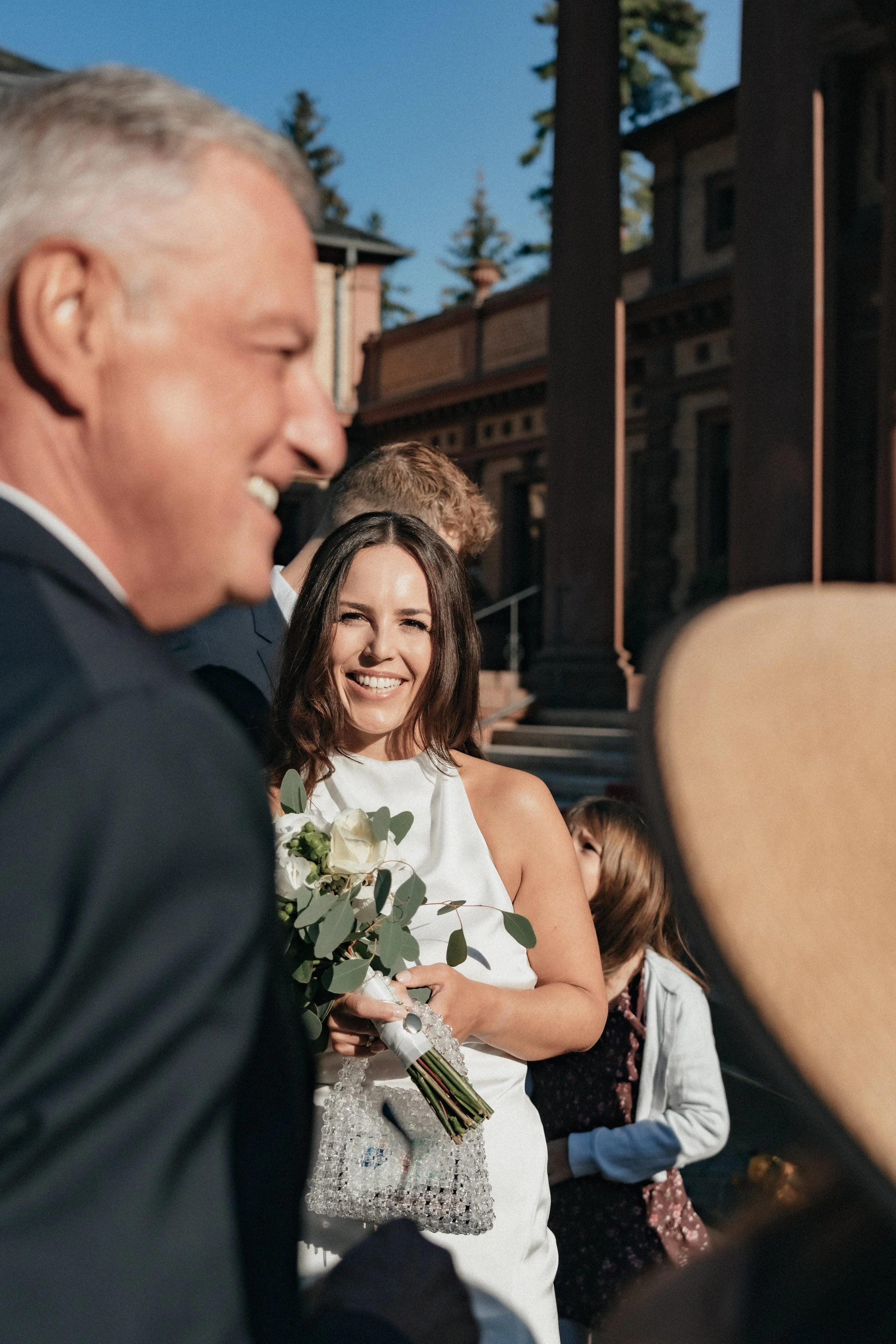 Bride smiling at her family picture taken by destination wedding photographer Di Salvo.
