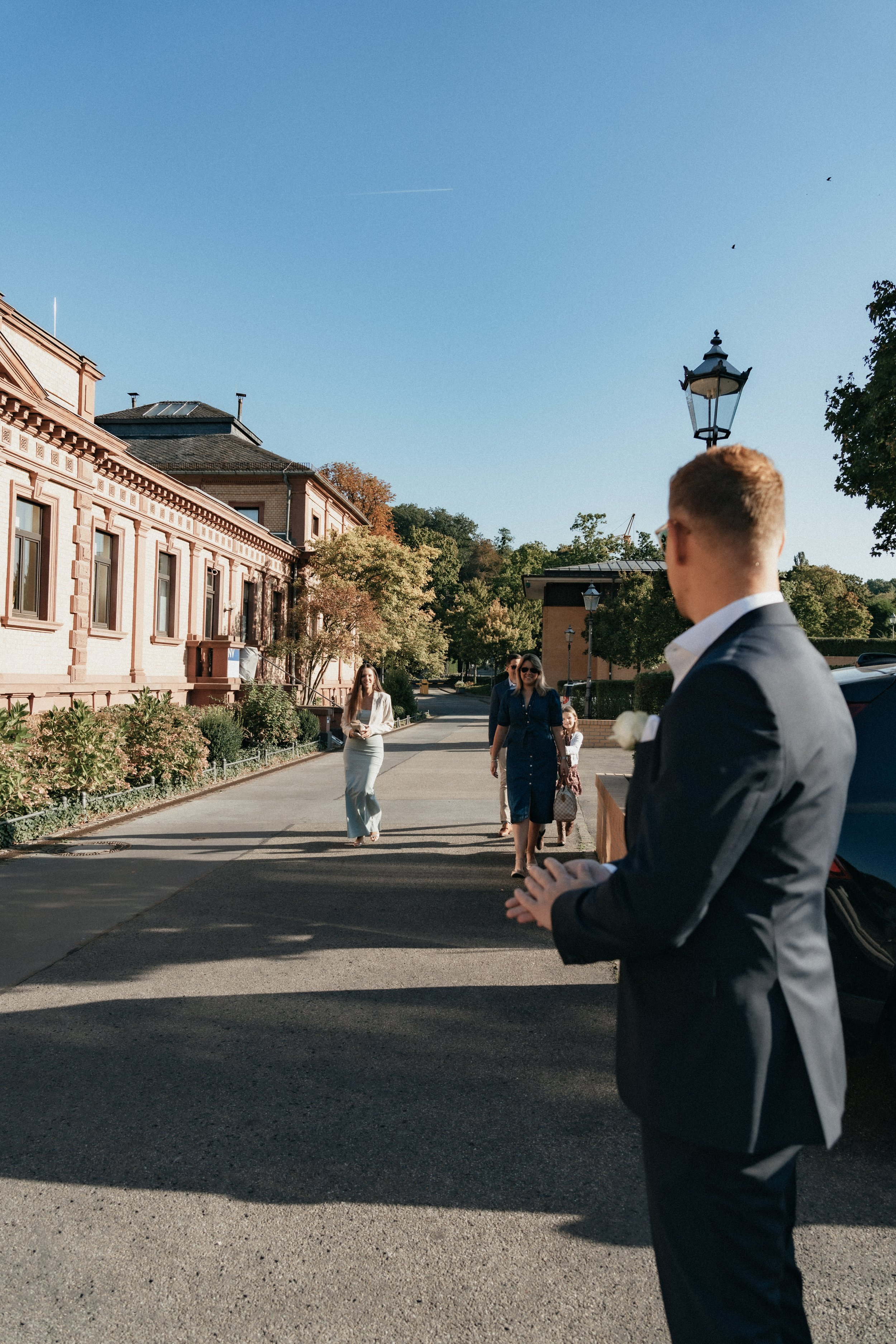 Groom waiting for guests to arrive outside of the civil wedding hall, Bad Homburg, Germany.