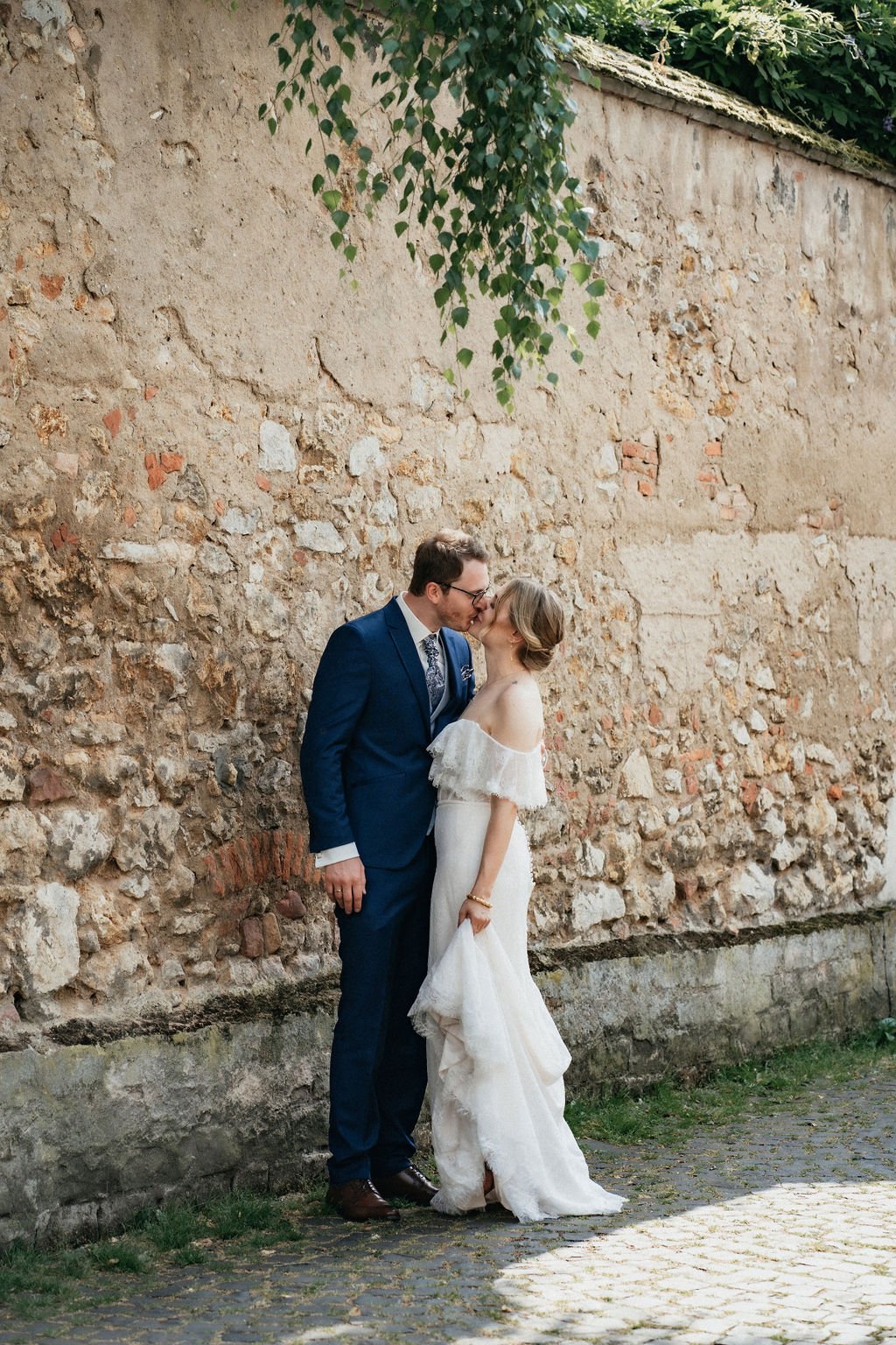 The Kiss of a married couple in front of a beautiful stone wall captured by wedding photographer Di Salvo.