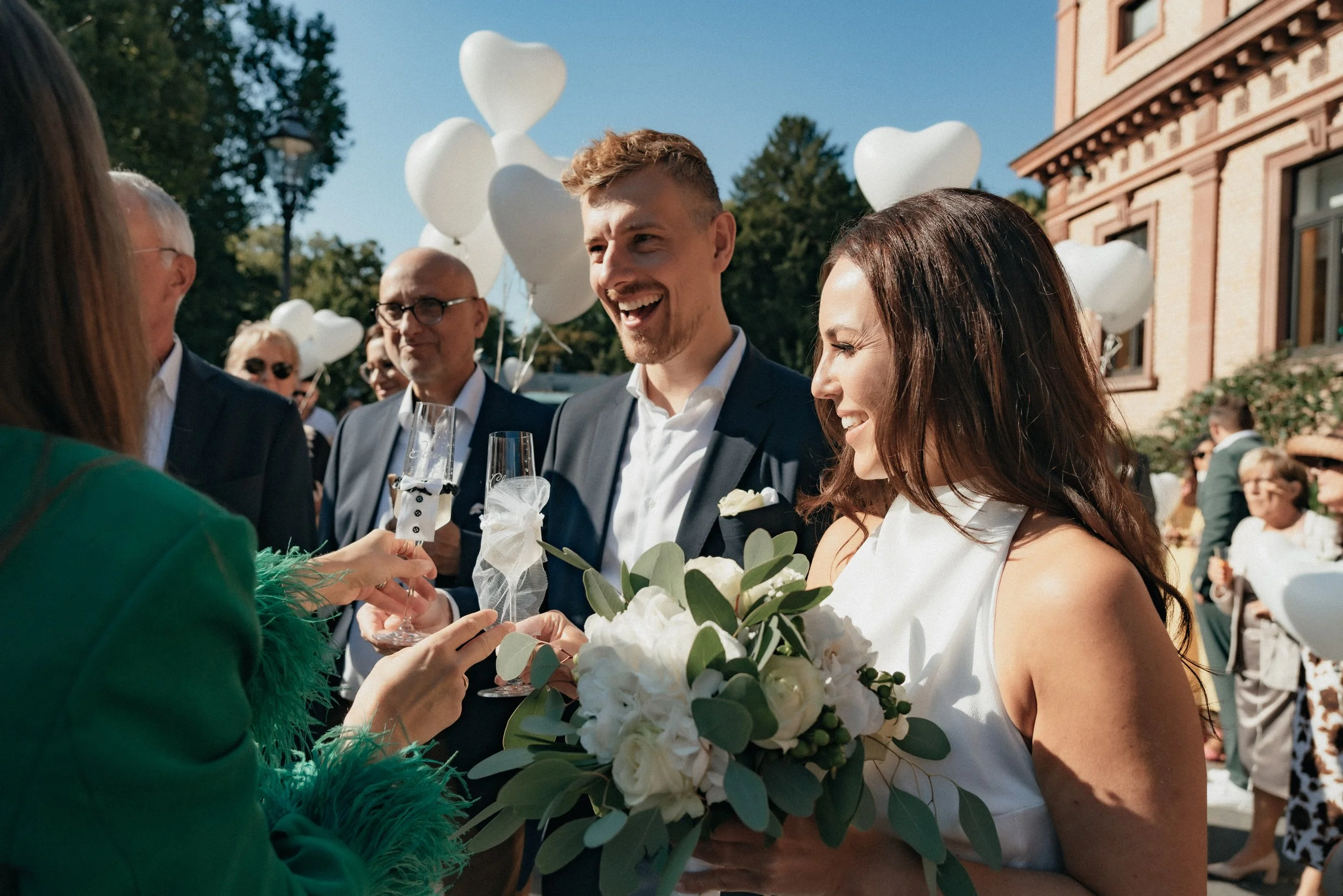 Couple cheering to their marriage with wedding guests in Bad Homburg, Germany.