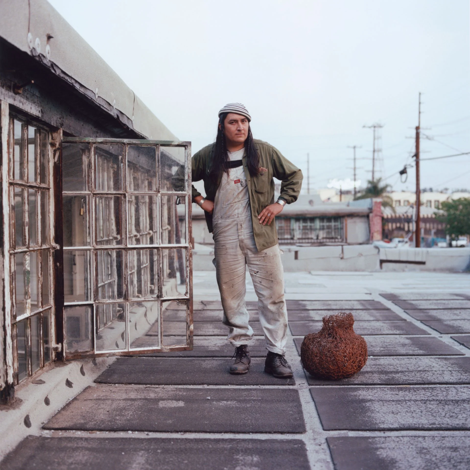 Ishi is a self-taught artist whose artwork often illustrates traditional techniques of his tribe, the Tohono O’odham Nation of Arizona, with a contemporary twist to pay homage to his heritage. Pictured, he stands on the roof of his studio in downtown