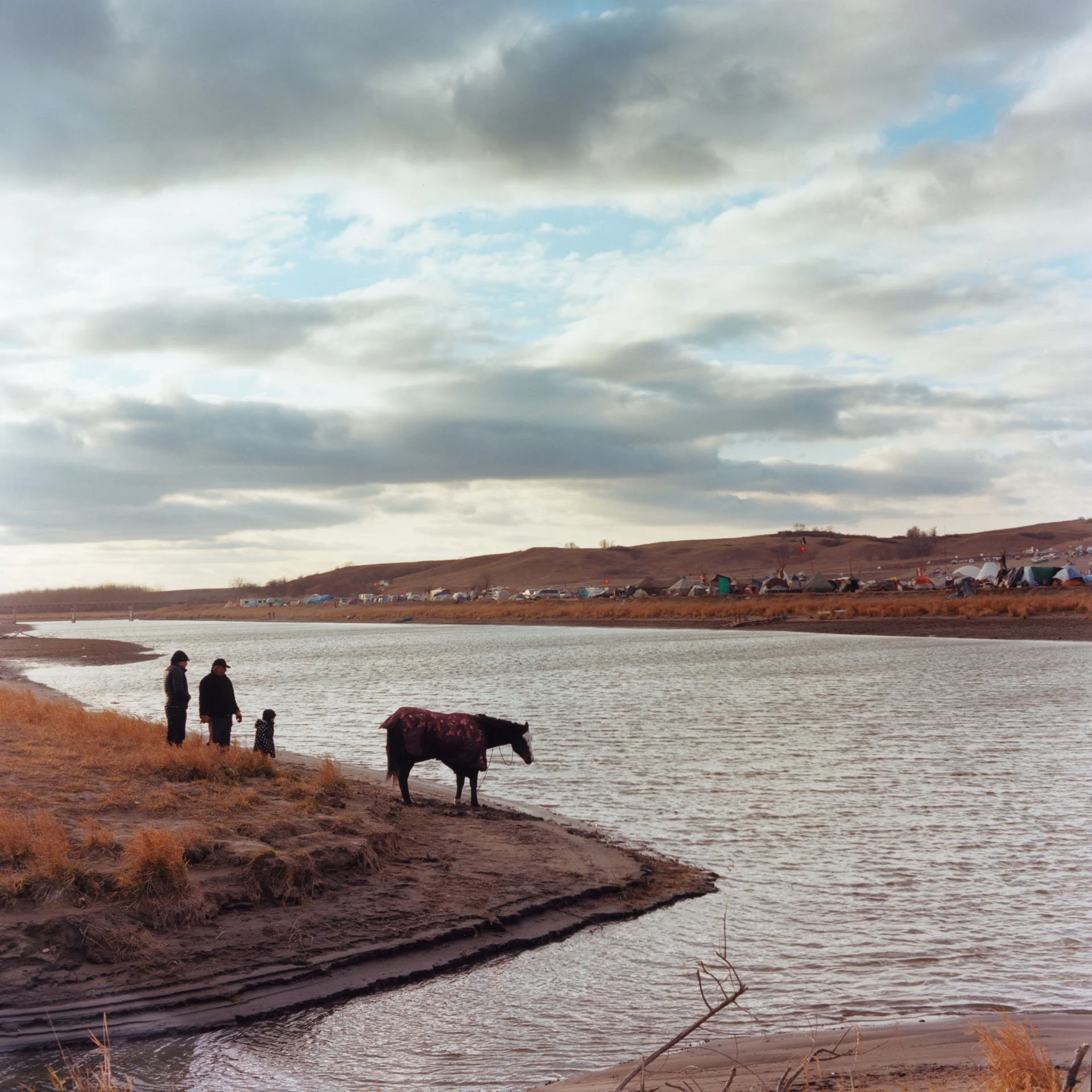 Family with horse by the River at the Očhéthi Šakówiŋ Camp.