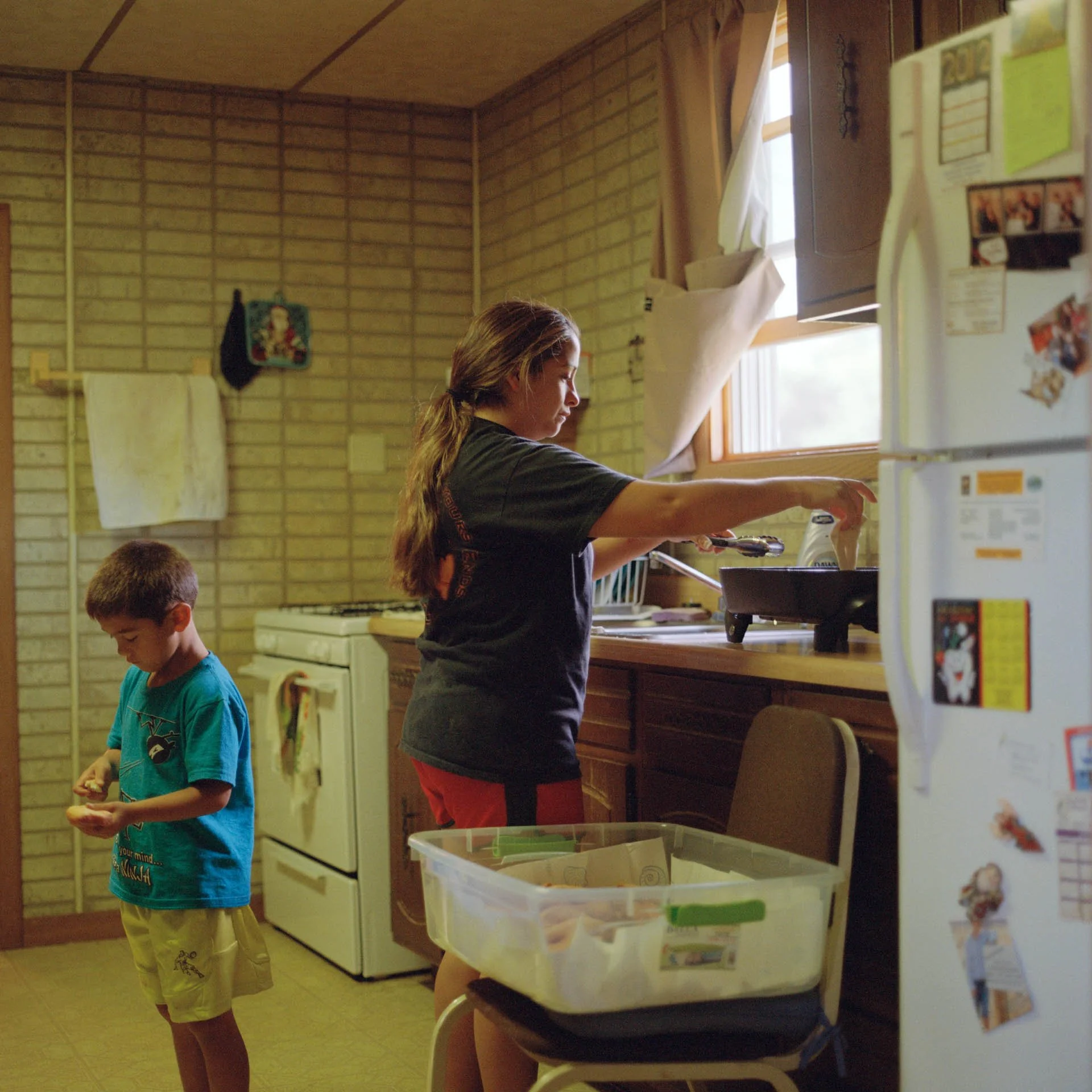 Gina, Lakota, works in her kitchen making home made fry bread for an upcoming family ceremony. She lives on the Standing Rock Sioux Reservation and raises her two sons while working as the only woman tribal police officer on her reservation.