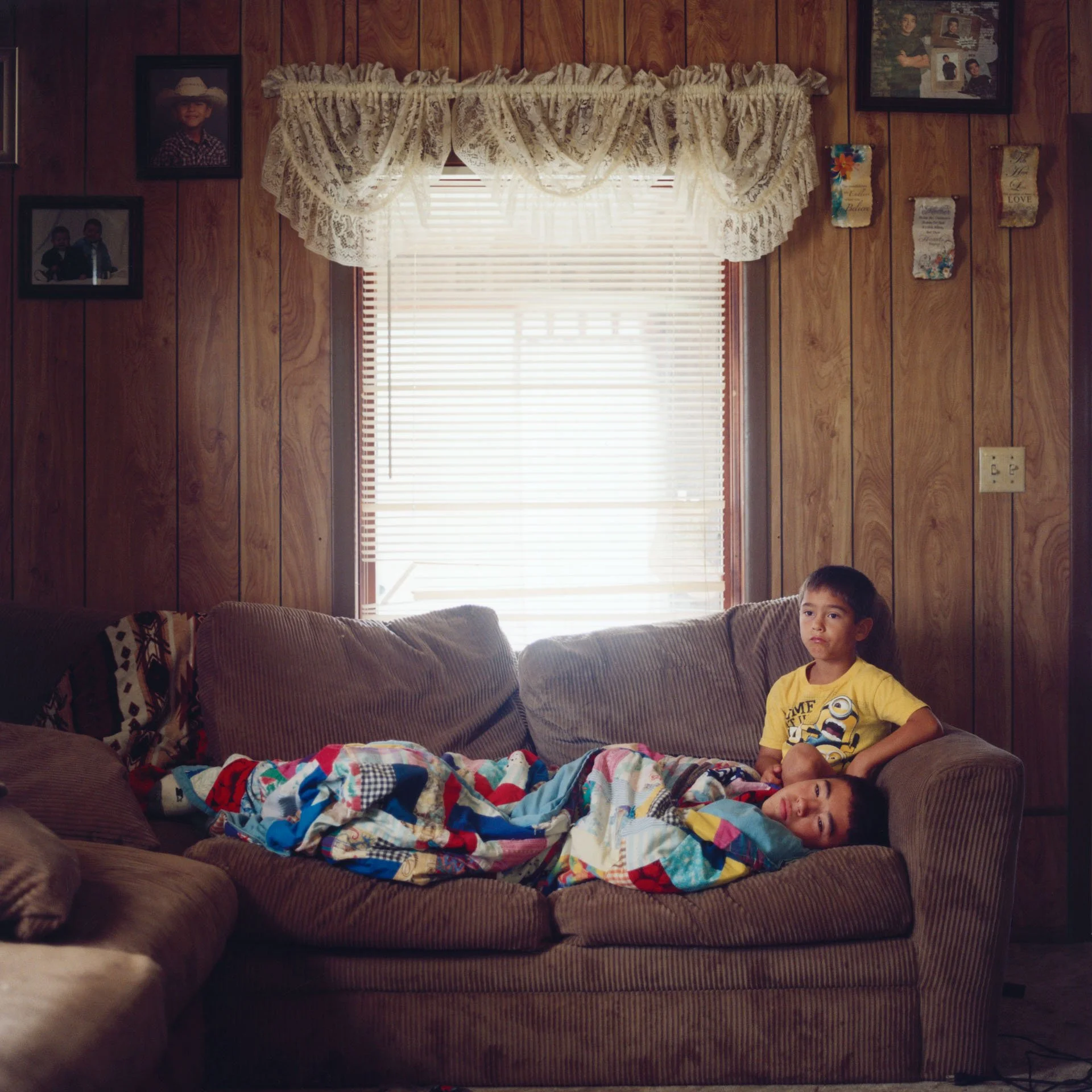 Two brothers, Hudson & Alex, watch TV on a Sunday morning while their iná (mother) makes fry bread from scratch in the kitchen for an upcoming ceremony.