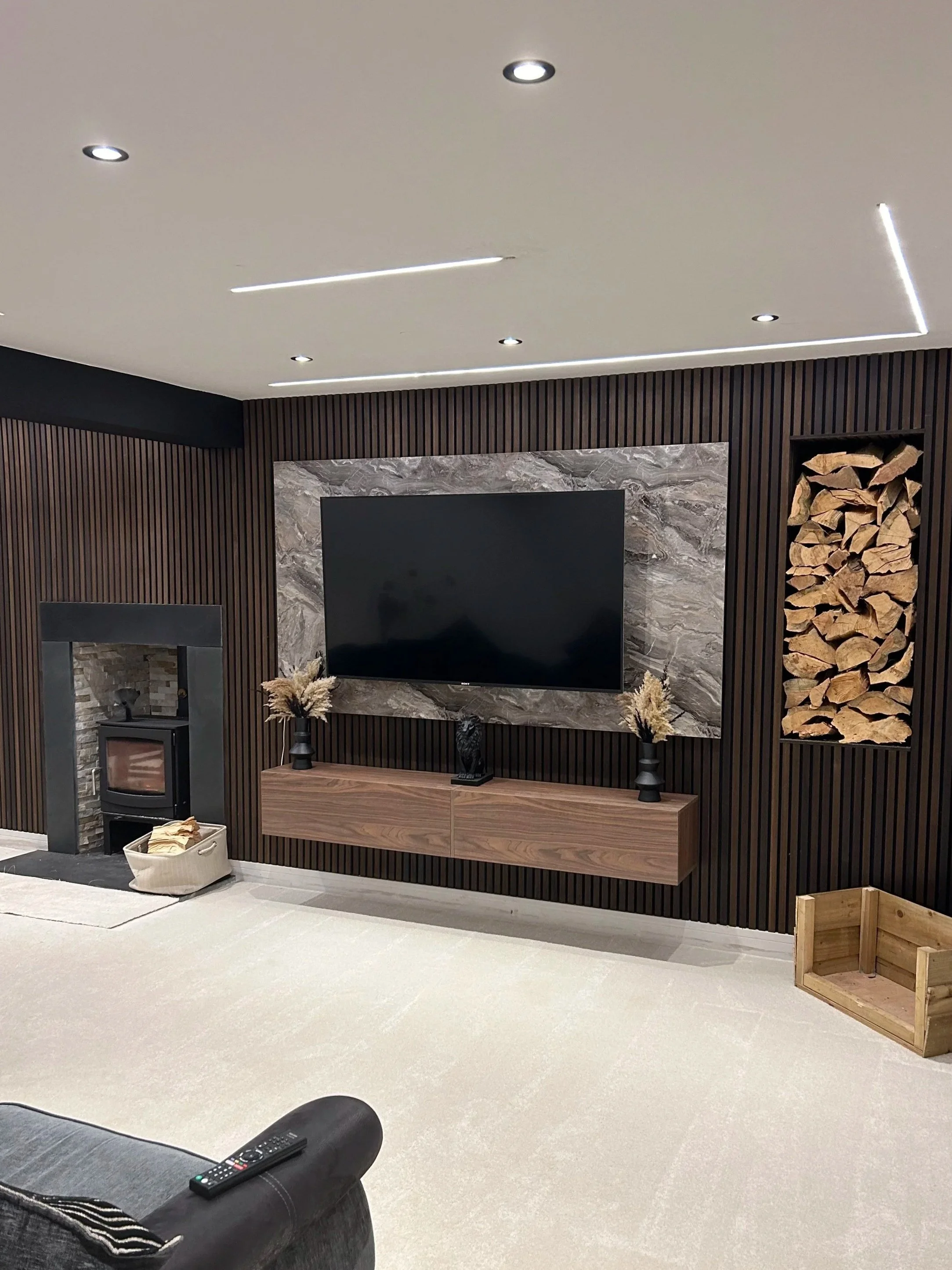 Modern living room with a TV on a media wall.