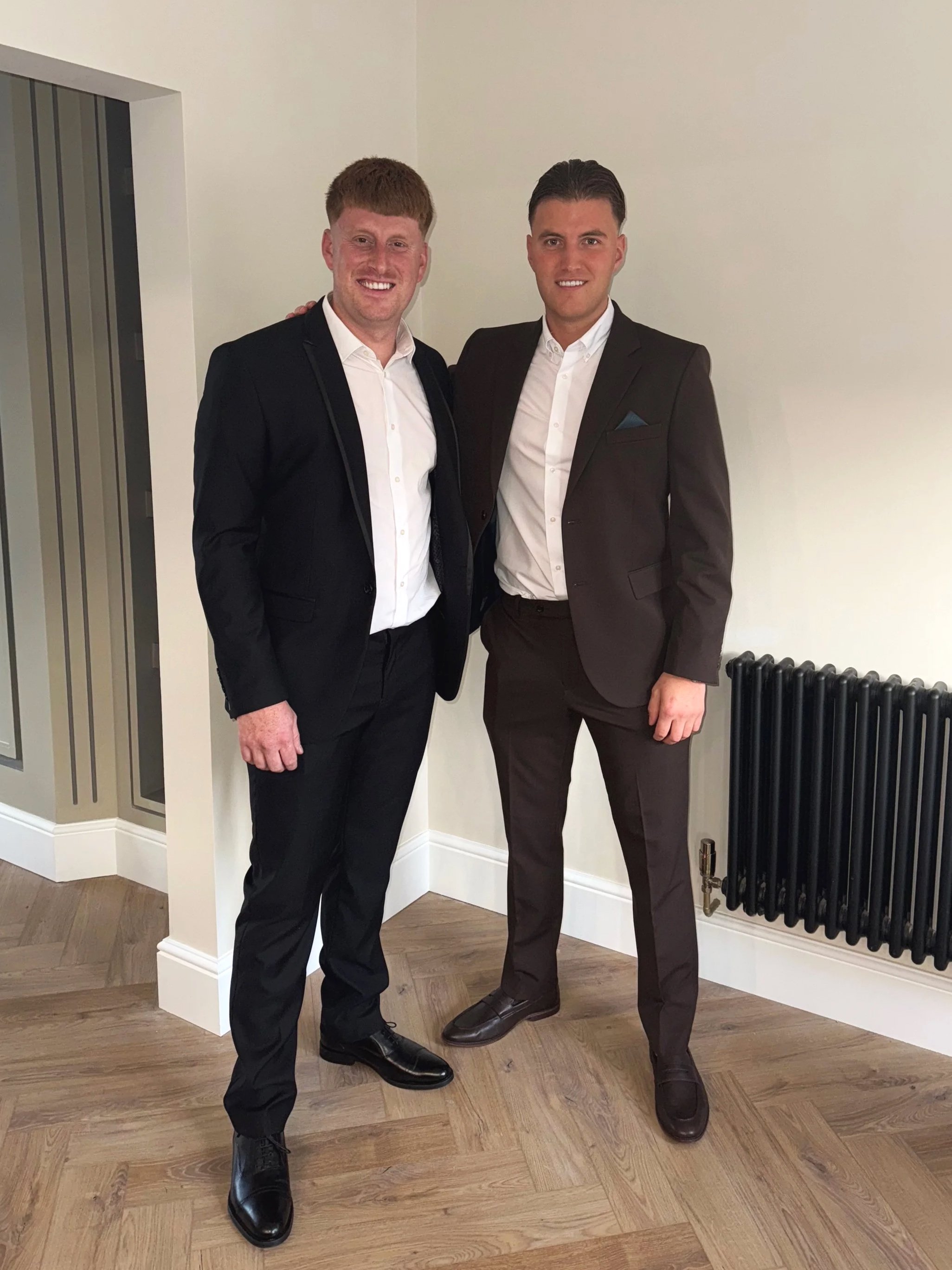 Directors of District Carpentry & Building Ltd in suits smiling.