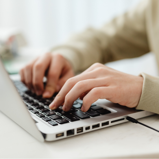 A person's hands on their laptop working on a website to get them ranked and recognised