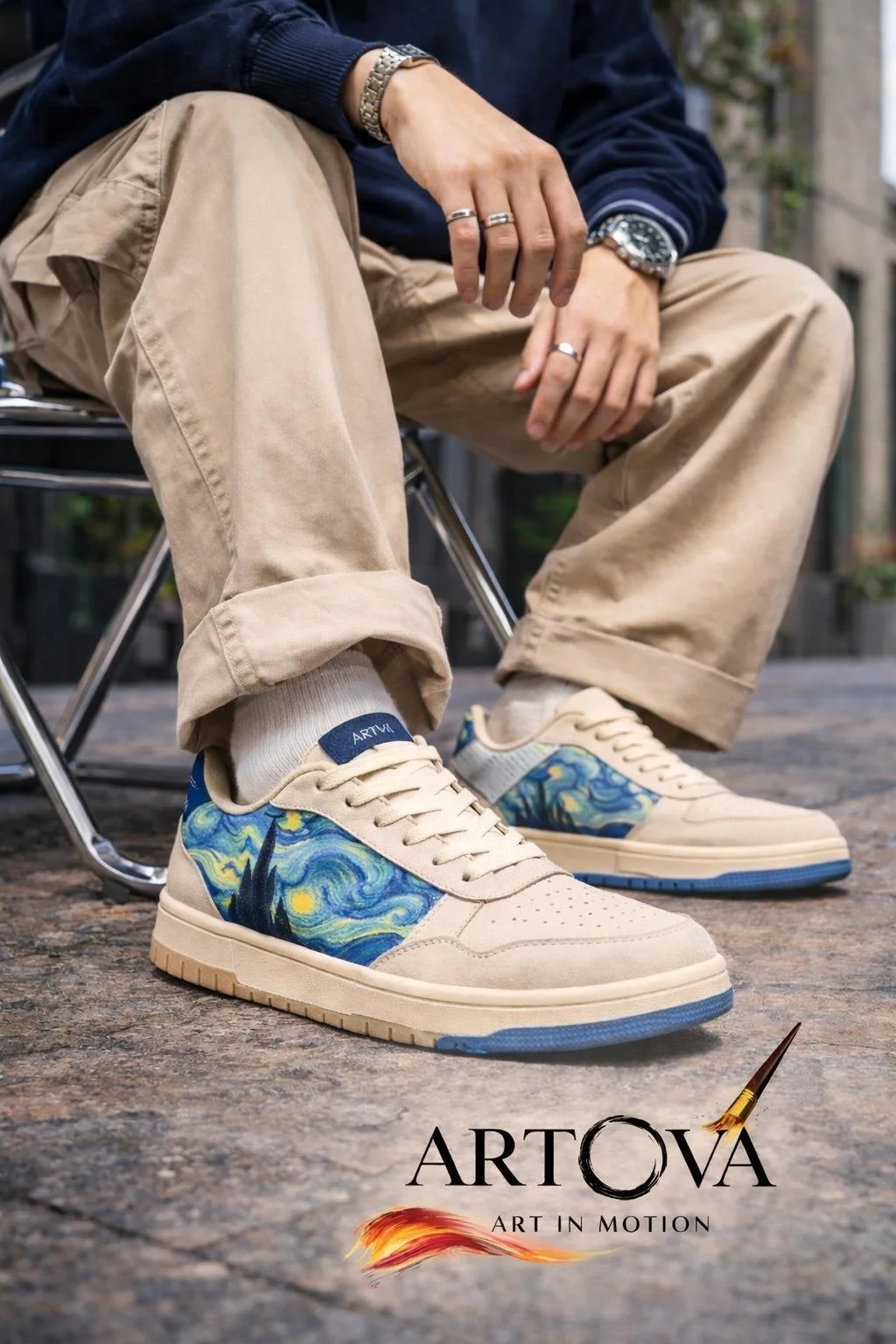 Nahaufnahme eines Mannes, der beige Turnschuhe mit einem Van Gogh inspirierten Sternenhimmel Design trägt, sitzend auf einem Stuhl im Freien. Es ist ein Kunstprojekt vom Maler Sameh Zaky.