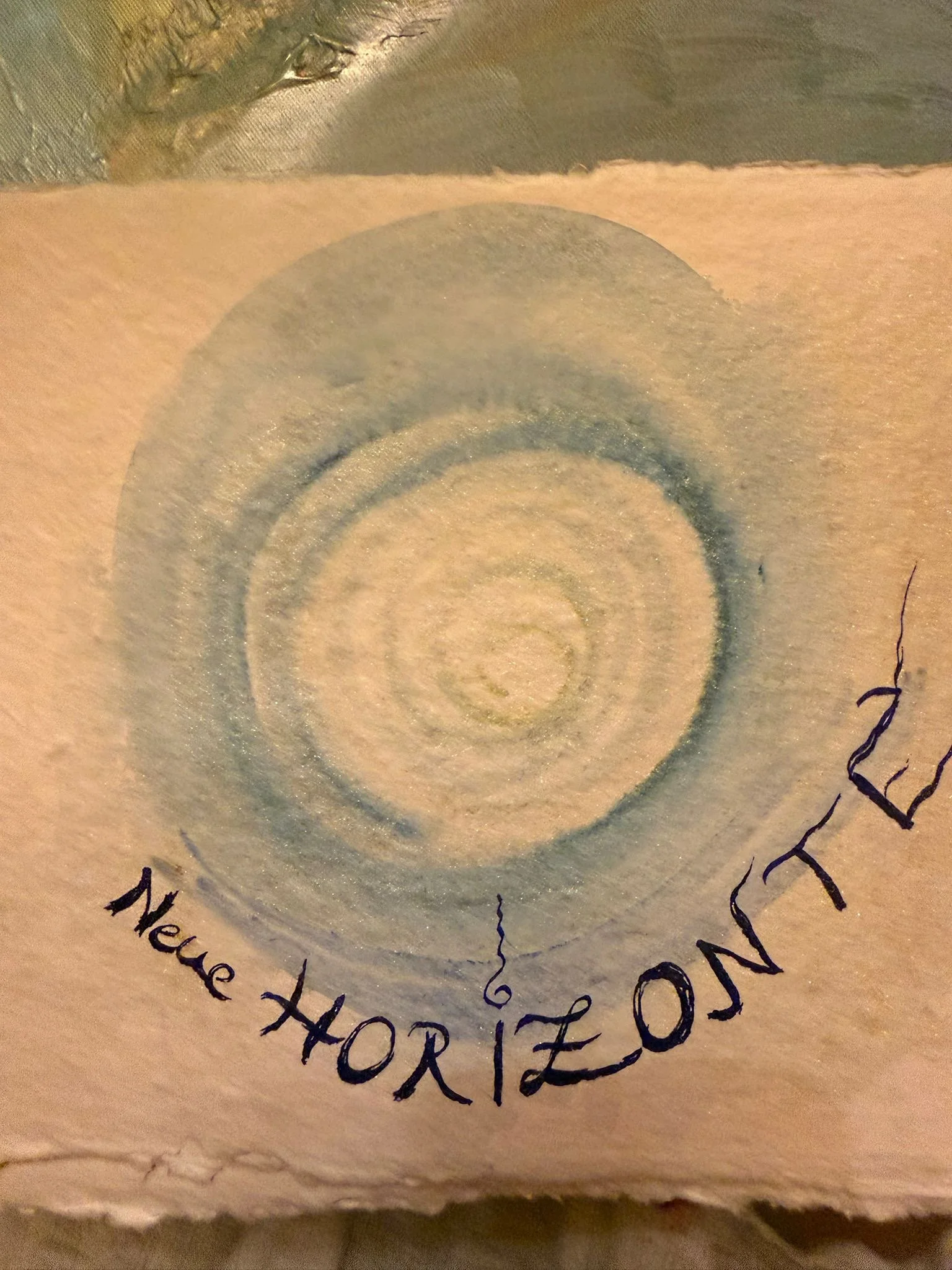 Der Blick auf eine Spirale, die von hand geschriebenen Worten umgeben ist, darunter 'neue Horizonte'. Es ist gemalt von der Verlagsgründerin Anja Dreier.