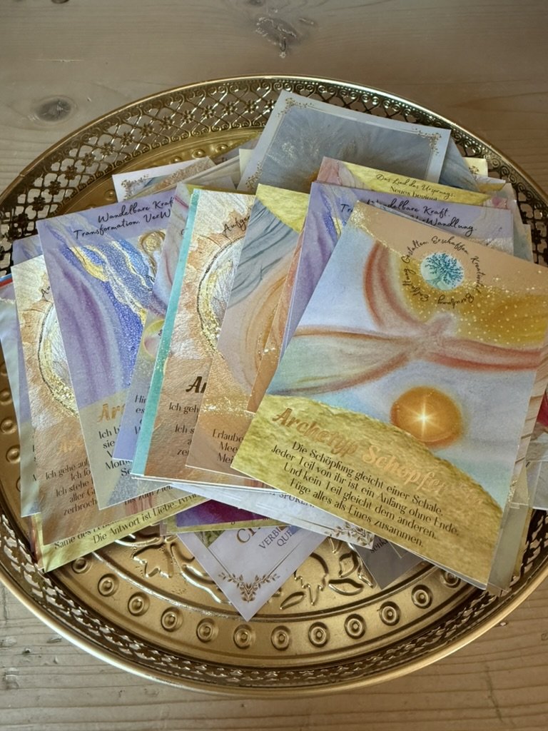 Mehrere geistige oder spirituelle Karten mit bunten abstrakten Bildern auf einem goldenen Tablett