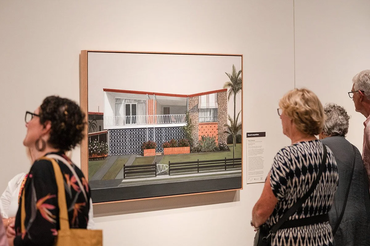 People viewing an architectural drawing of a modern house in an art gallery