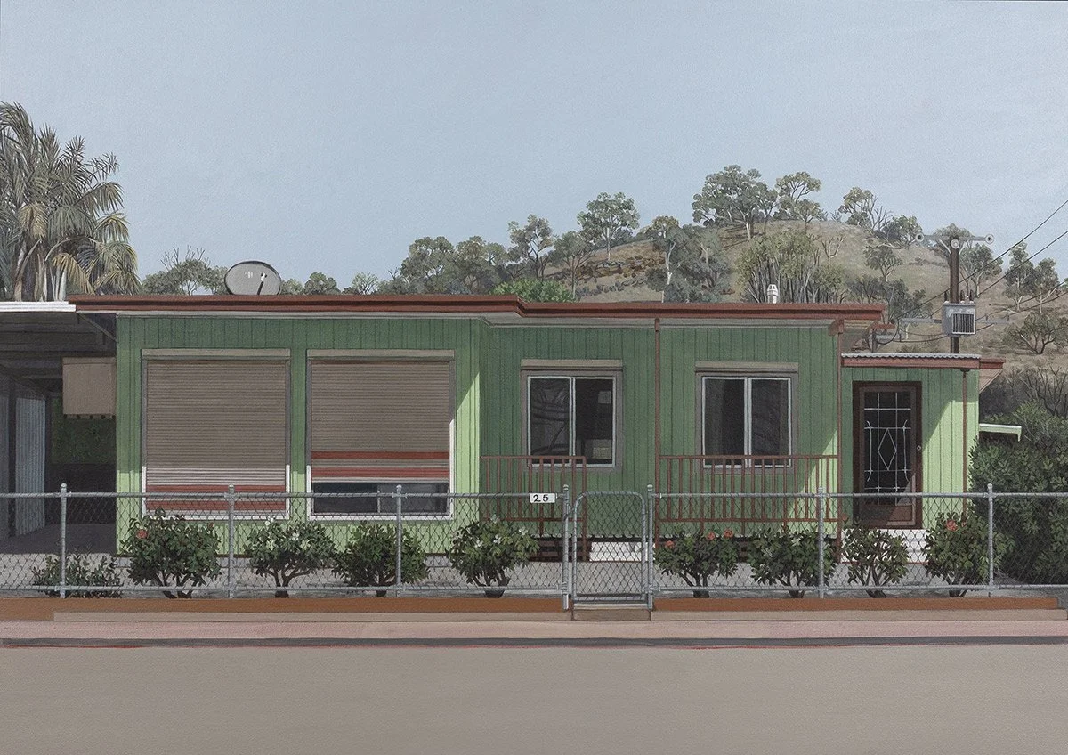 A small, green house with a brown roof, three windows, a door, and a front fence with bushes. Hills and trees are in the background.