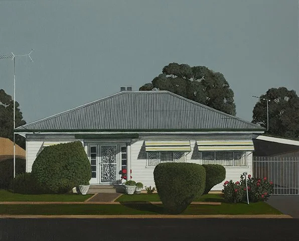A single-story house with a metal roof, white siding, and a front yard with bushes, potted plants, and a lawn, in a suburban neighborhood.