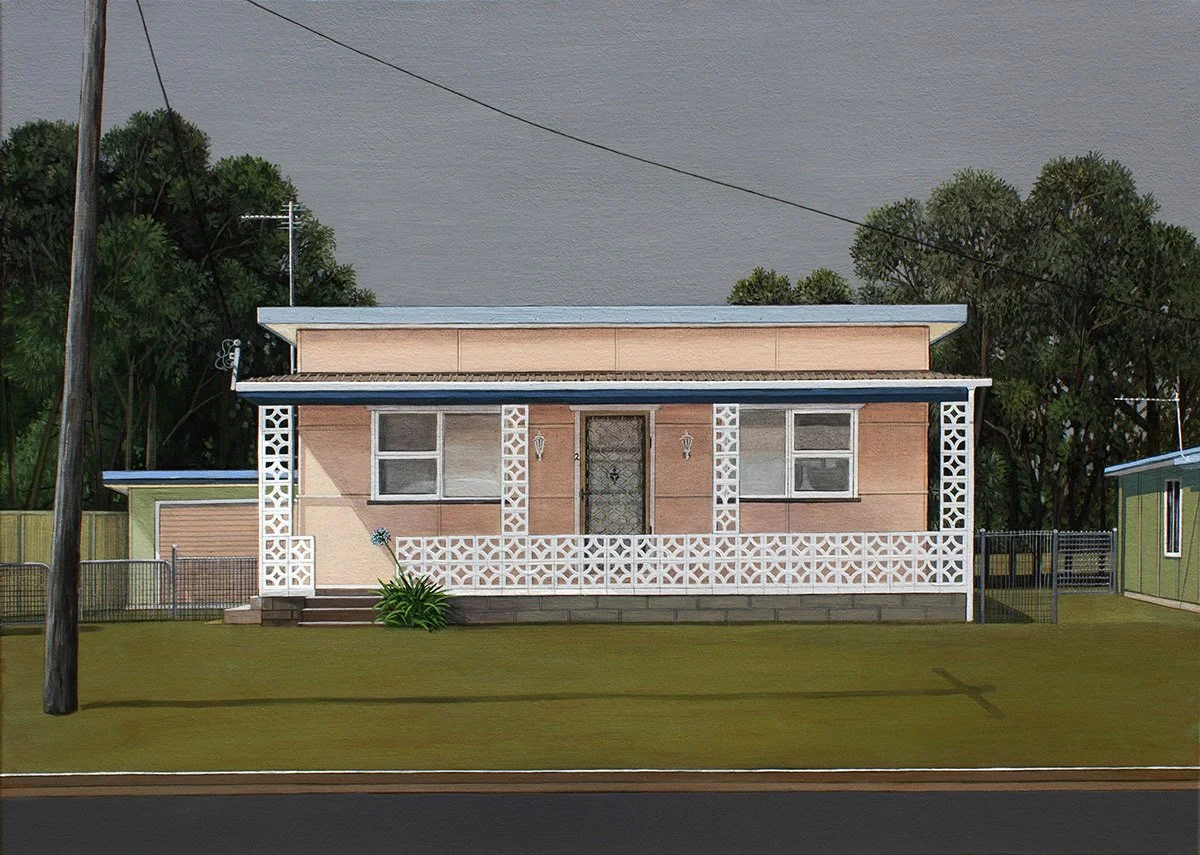 A single-story house with a light pink exterior, white lattice accents, and a small front porch with stairs, surrounded by a yard with green grass and trees in the background.
