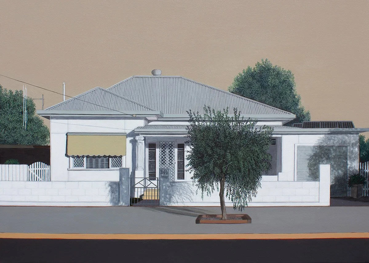 A house with a gray metal roof, white walls, a small front porch with a set of stairs, a yellow awning over a front window, a tree in front, and a driveway with a garage. There are trees and utility lines in the background.