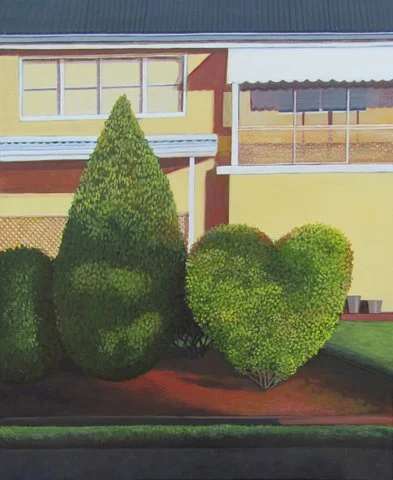 Well-maintained front yard with three green bushes, one shaped like a cone and two rounded, in front of a yellow house with large windows and a porch.