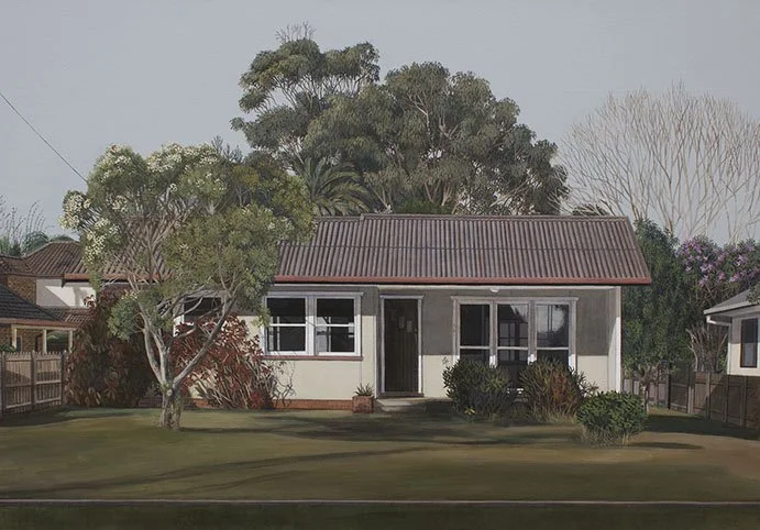 Front view of a house with a red-tiled roof, surrounded by greenery and trees, in a suburban neighborhood.