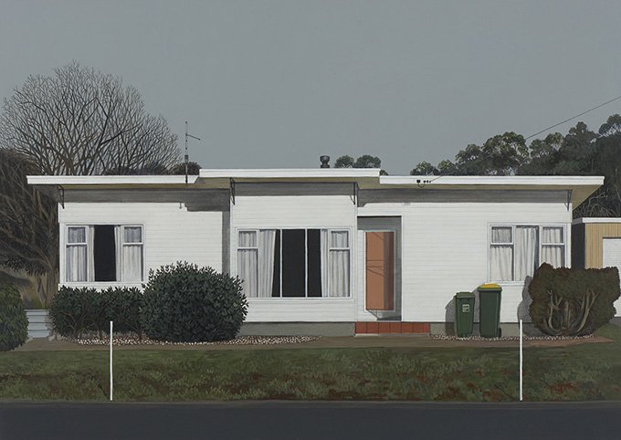 Single-story white house with three windows, a front door with brick steps, and three trash bins in the yard. There are bushes and a tree to the left and right of the house.