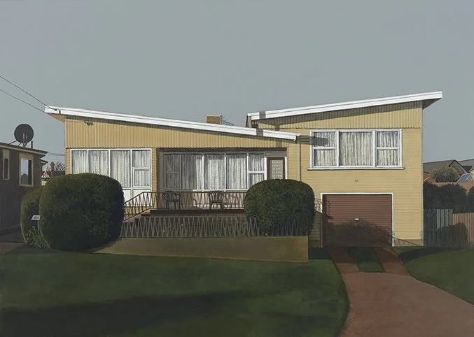 A yellow split-level house with a sloped roof, front porch, and attached garage, surrounded by a green lawn and bushes.