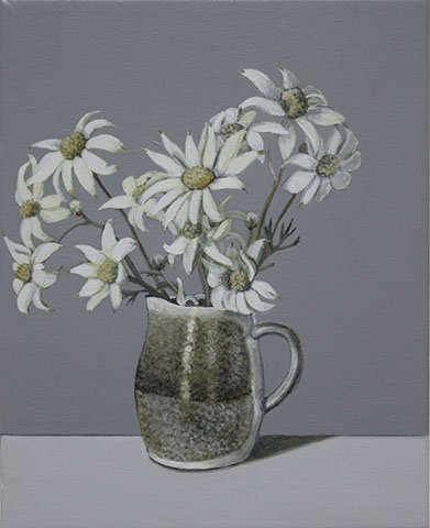 A gray ceramic pitcher with white daisies with yellow centers against a gray background.