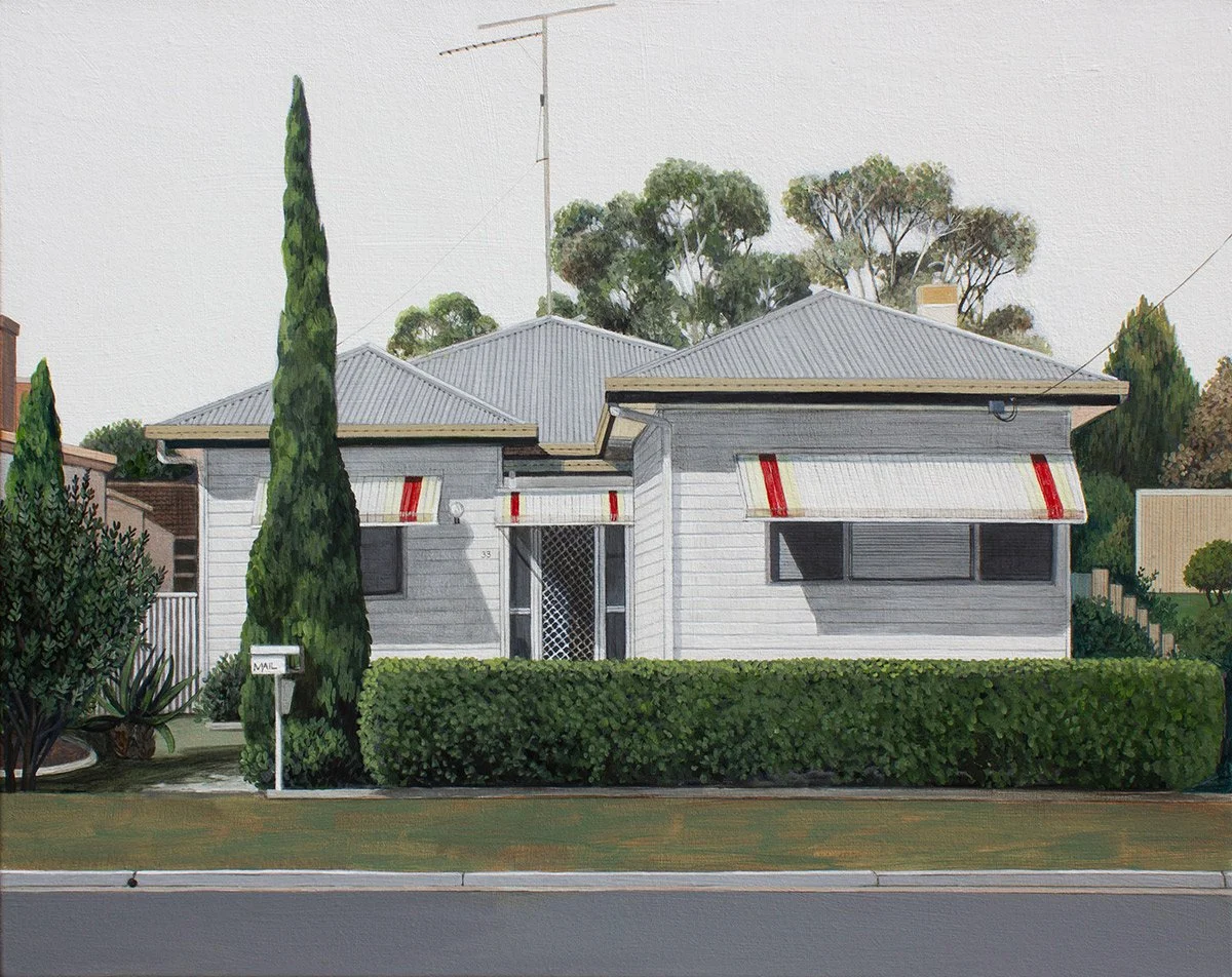 A residential house with white siding, a grey metal roof, red and white striped awnings over the windows, a hedge in front, and trees in the background.