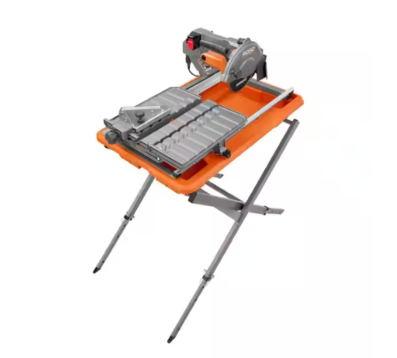 Portable tile saw with a cutting blade, adjustable guide, and a metal stand with four legs, mounted on an orange work surface.