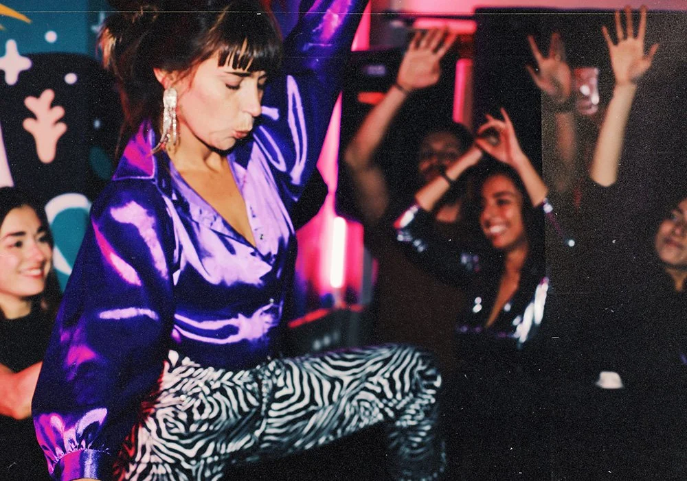 un DJ de discothèque en haut violet en train de danser
