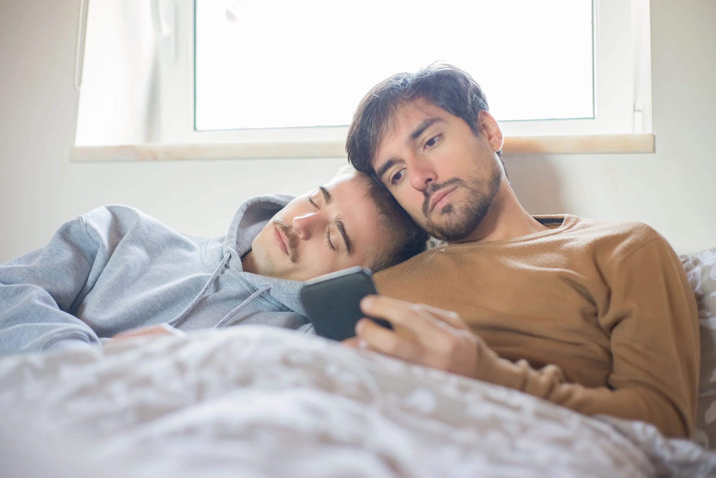 lgbtq looking at their phone with a stressed expression