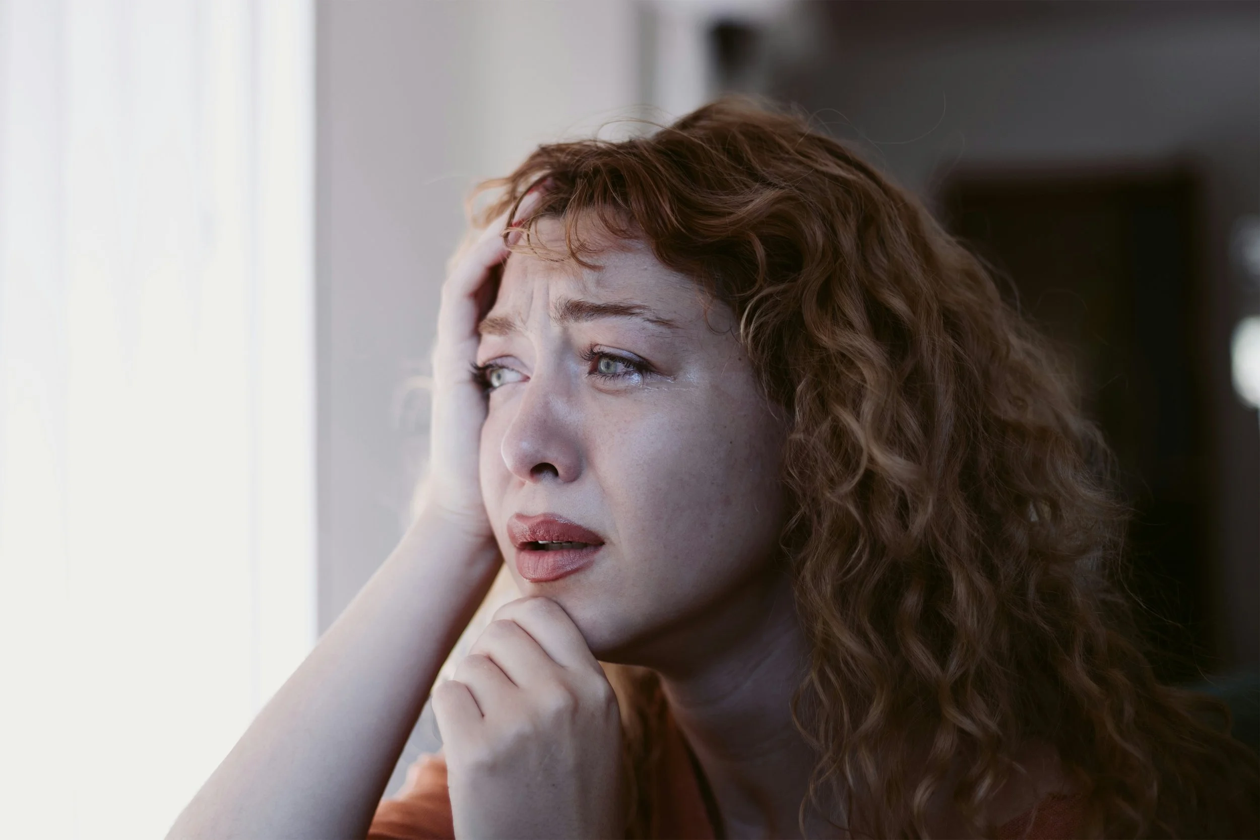 a sad woman is crying with tears of grief