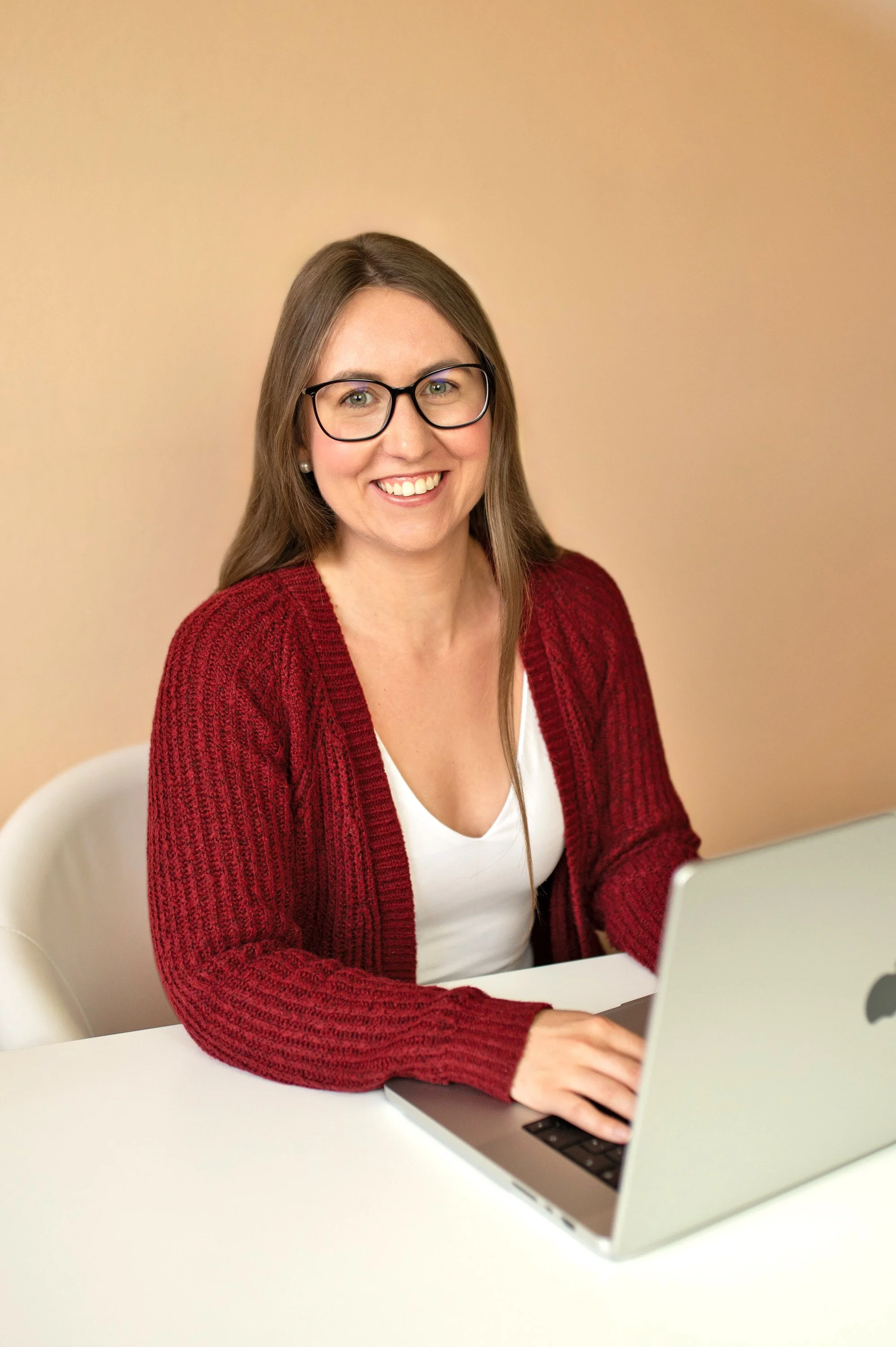 Eva Rieger lächelnd am Schreibtisch mit  einem Laptop vor sich