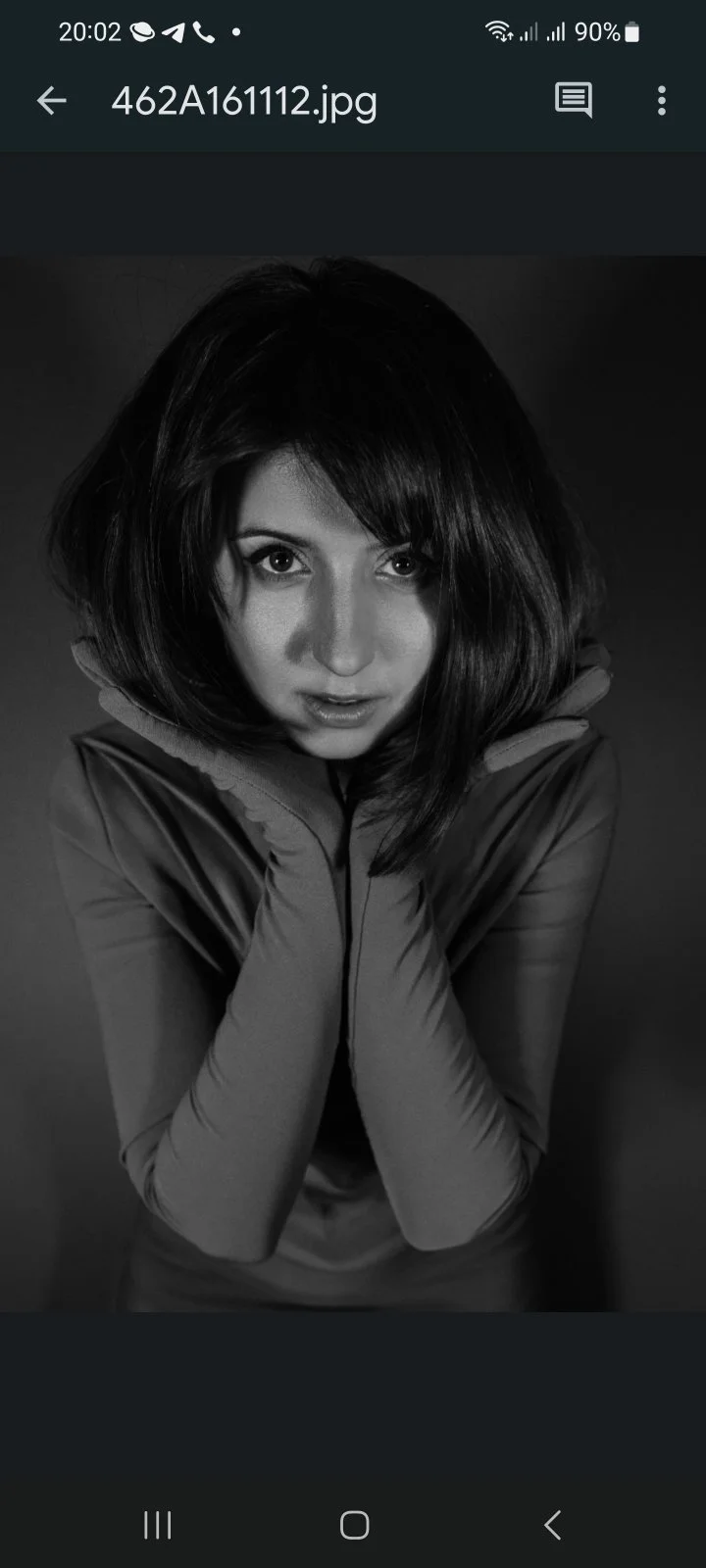 Black and white portrait of a woman with dark hair, looking directly at the camera with a slight smile, wearing a jacket.