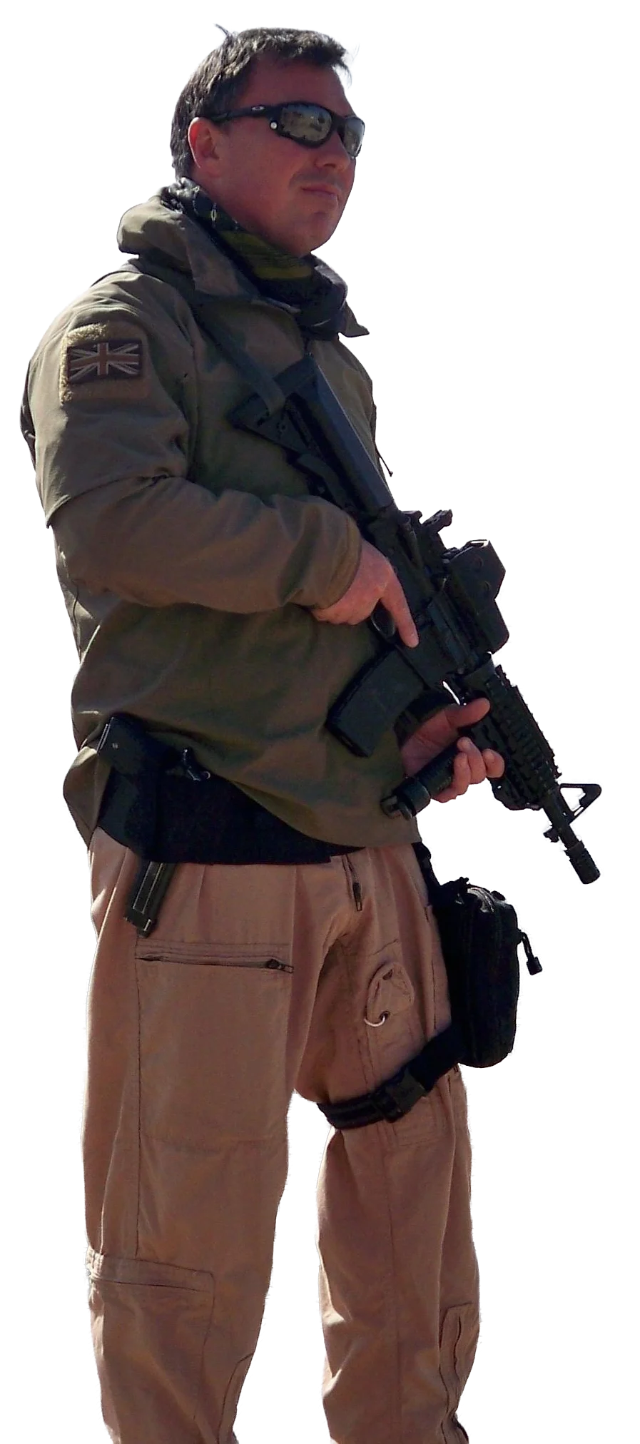Man wearing sunglasses in military or tactical clothing, holding a firearm.
