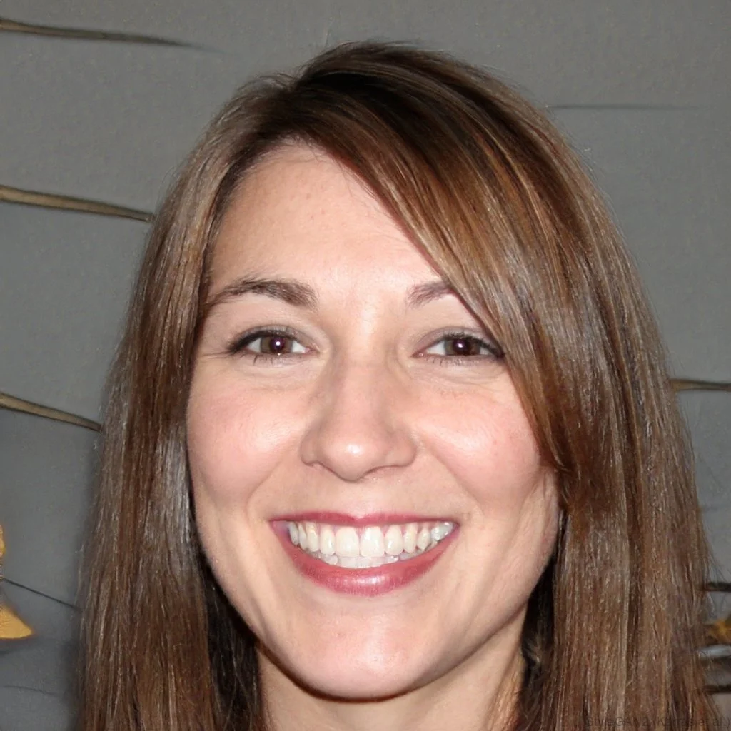 Close-up of a smiling an american accent coach student who's a woman with straight brown hair and light skin, indoors.