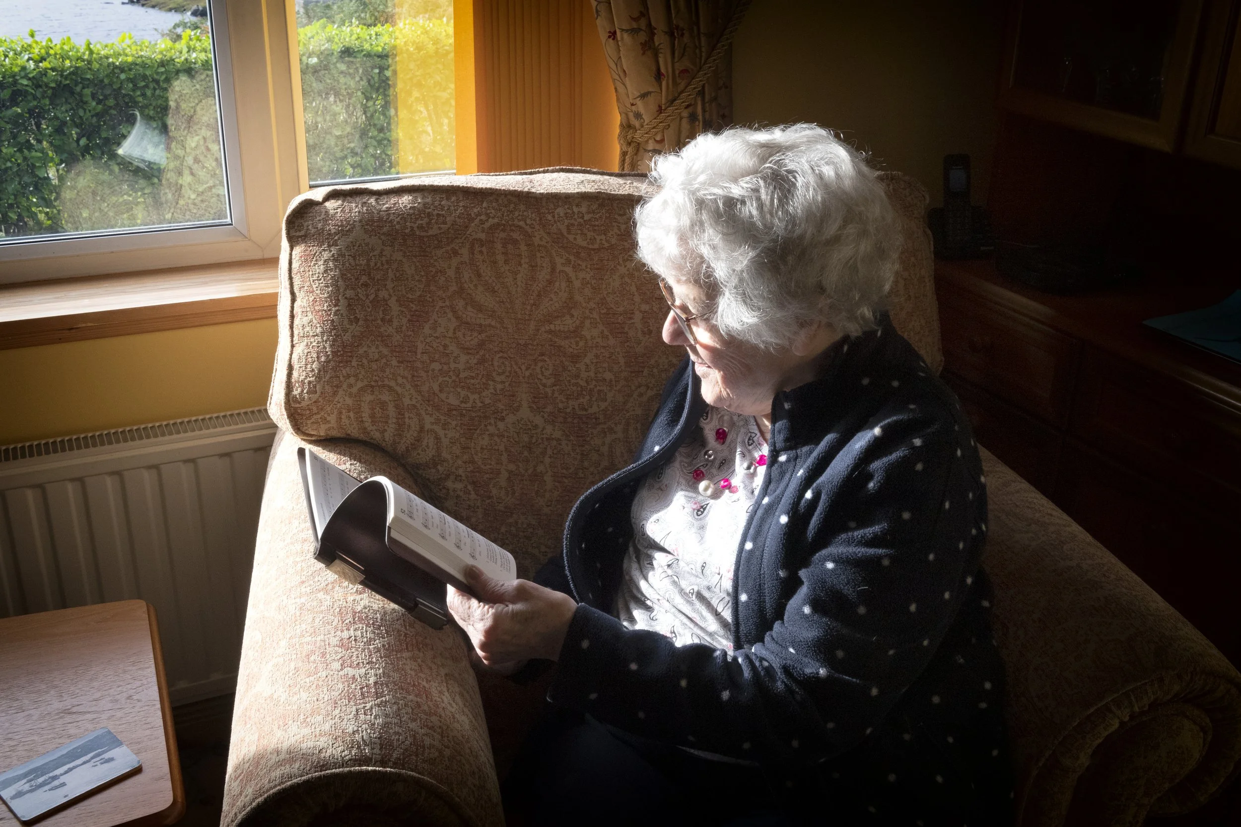 Morag MacLeod with Seinnibh dhan Tighearna hymnbook. Scalpay, Harris, October 2022. Photo by Mairi M Martin.