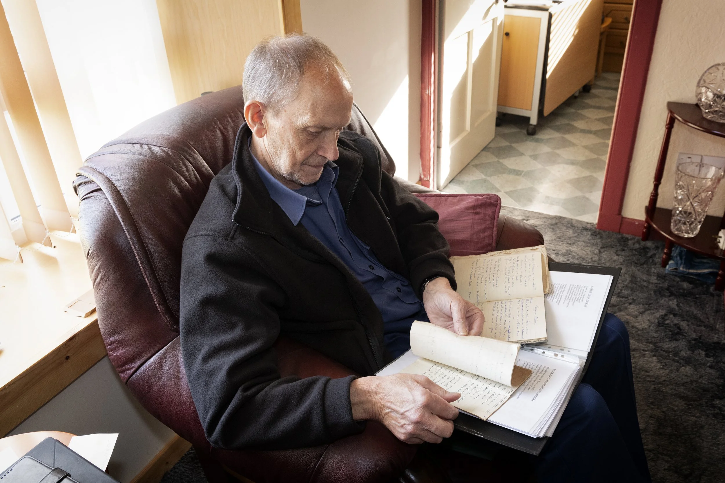 Murdo John Morrison with hand-written song collection. Fivepenny, Ness, Lewis. October 2022. Photo by Mairi M Martin. 