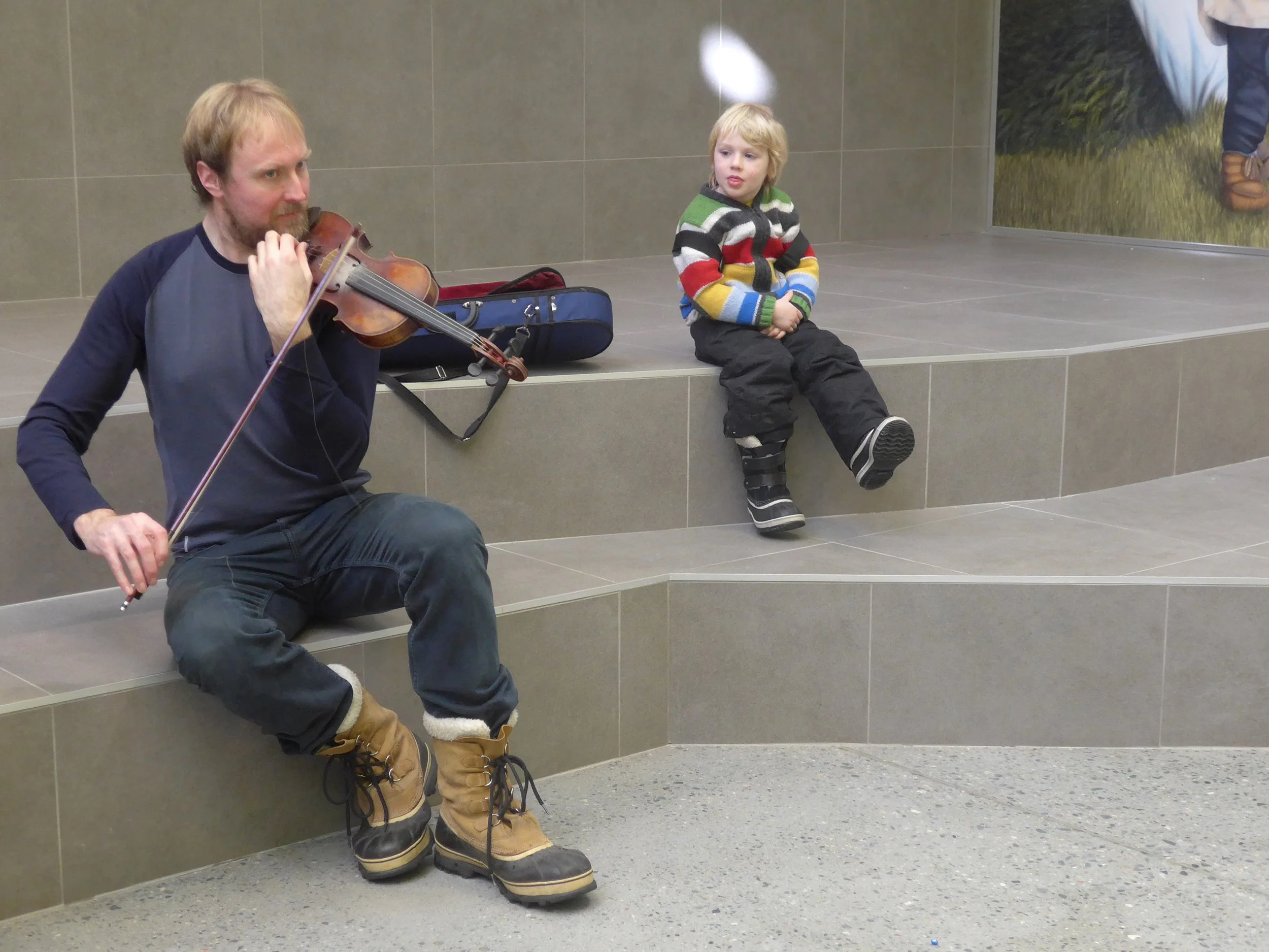 Ronan Martin, fiddler, with son Seumas, performing at the elementary school in Waskaganish, Eeyou Istchee, Québec. March 2018. Photograph by Frances Wilkins.
