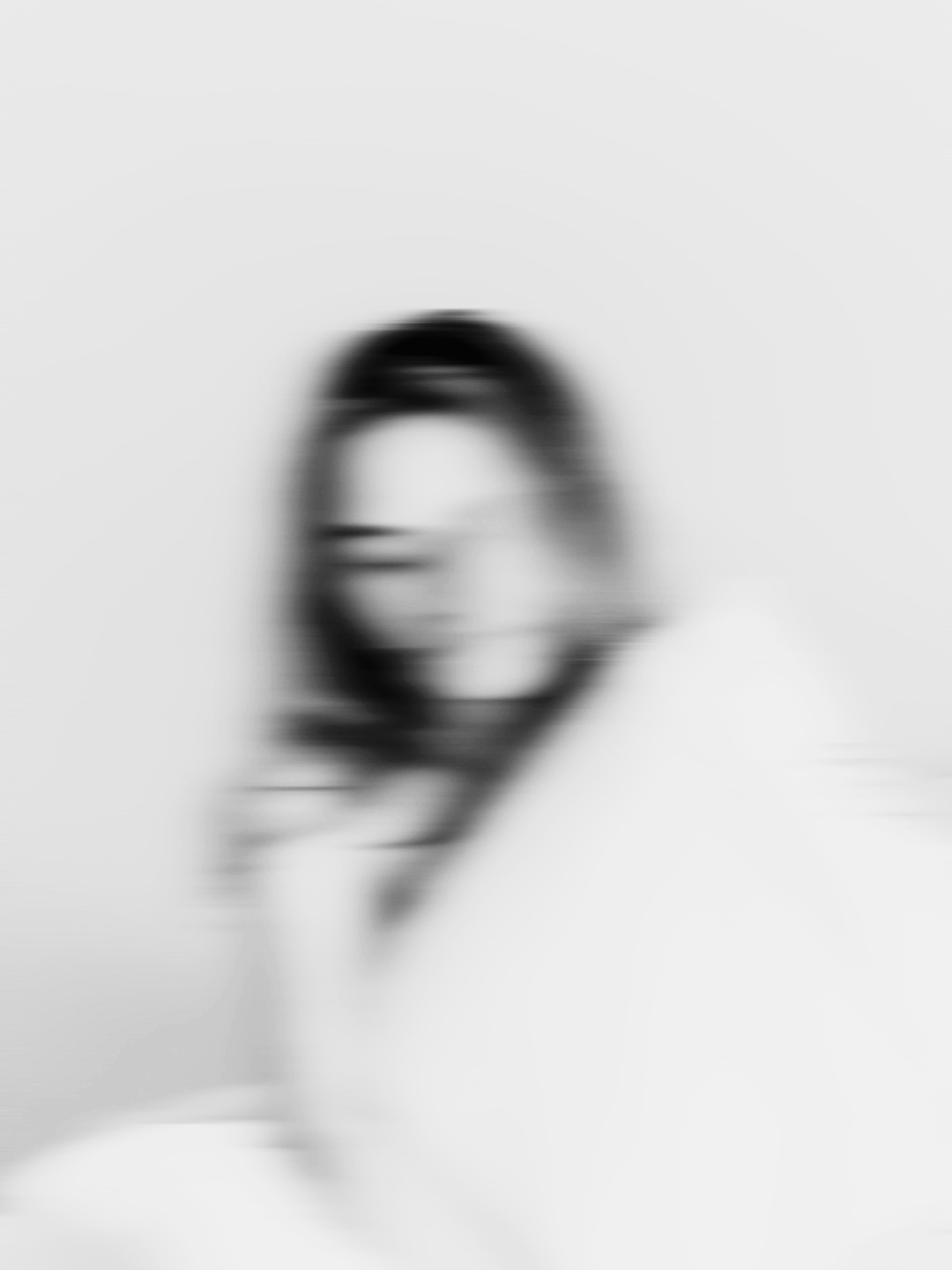 A blurry black and white photograph of a person holding a mirror in front of their face — representing the hidden signals in buyer behavior and sales conversations analyzed by Smith + Soma.