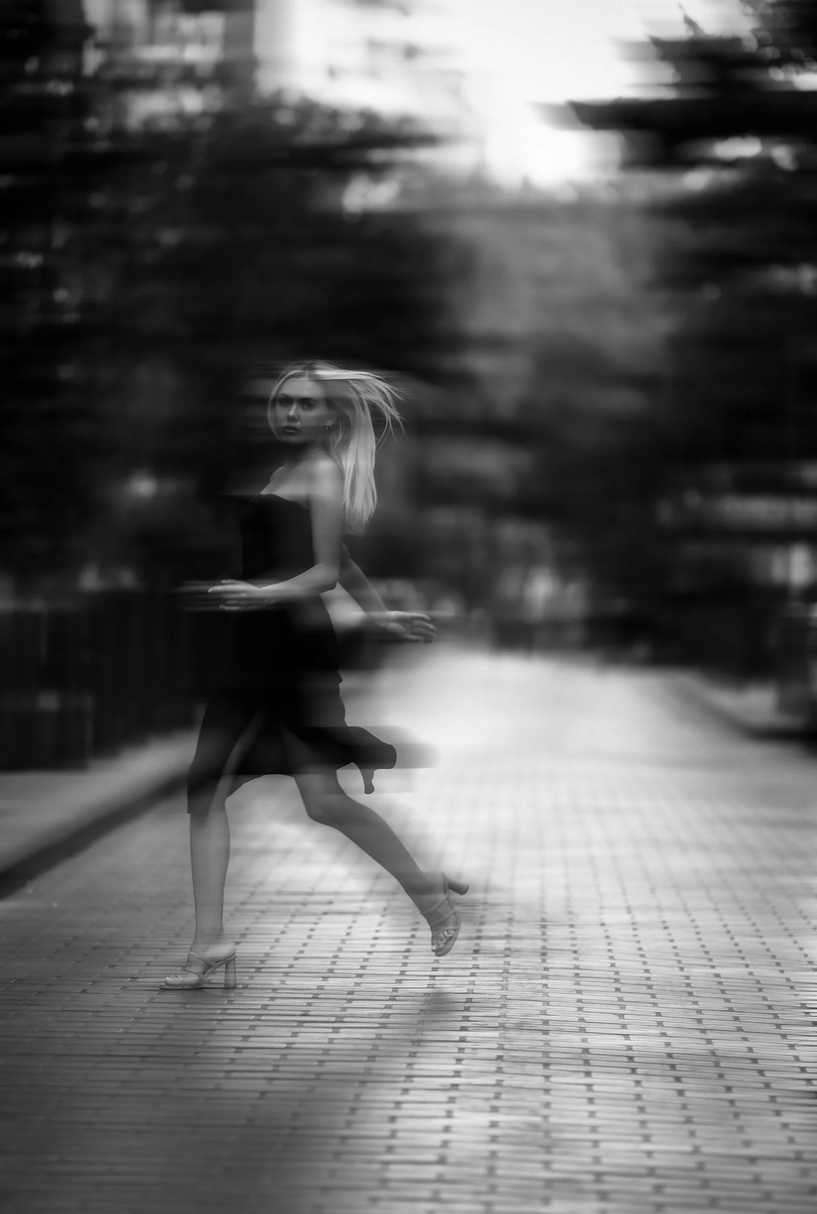 Black and white reflection of a woman crossing the street in the rain — evoking the hidden signals and emotional patterns in buyer behavior decoded by Smith + Soma nervous system analysis.